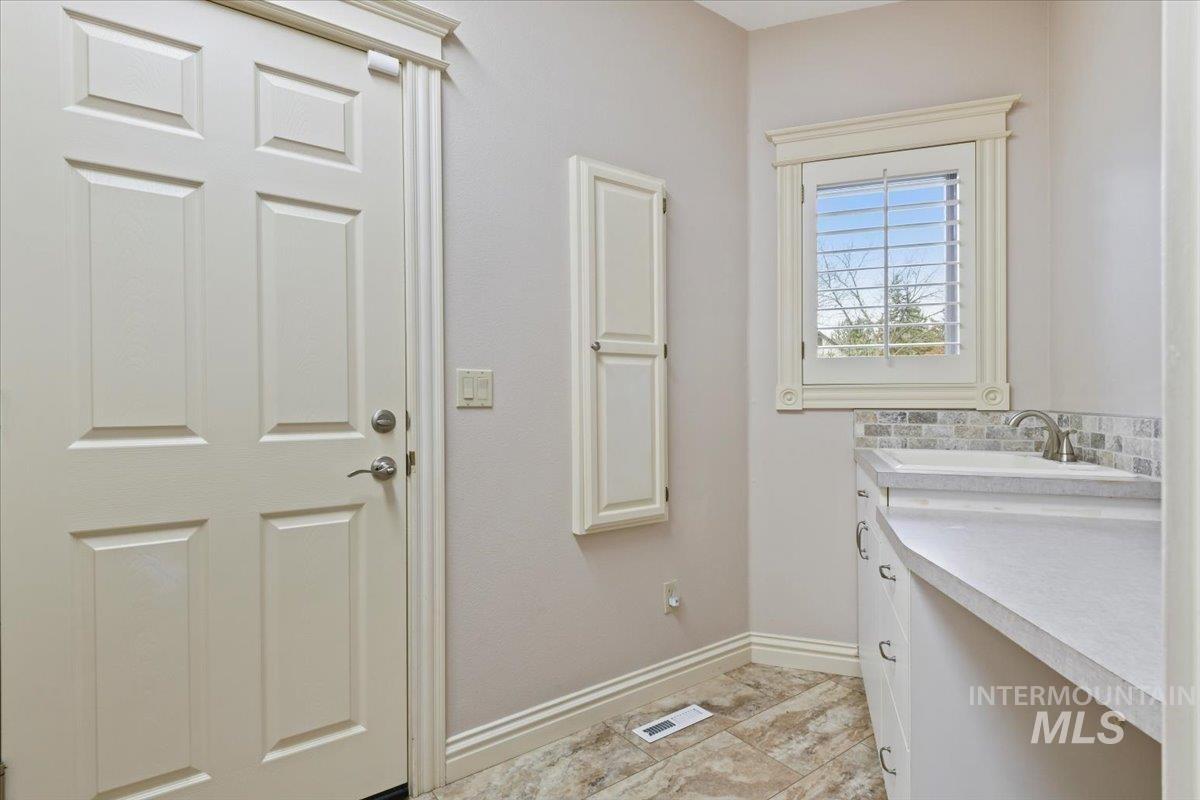 Washroom with baseboards and a sink