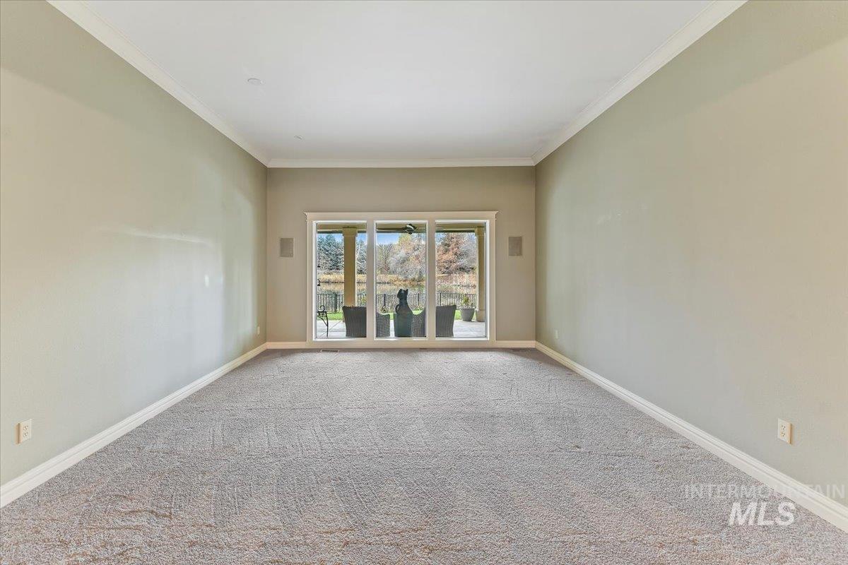 Carpeted spare room with crown molding