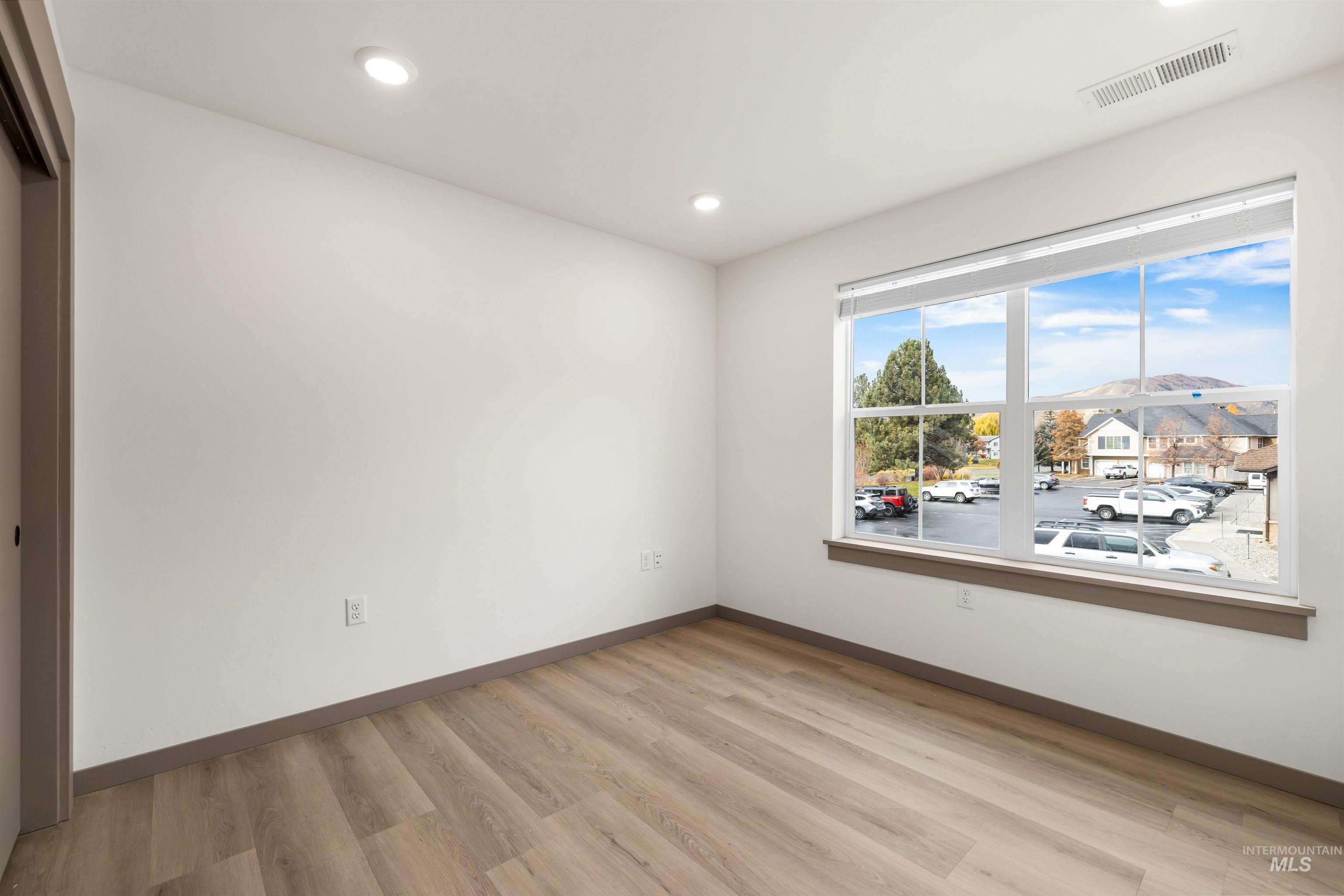 Spare room featuring light wood-style flooring and recessed lighting