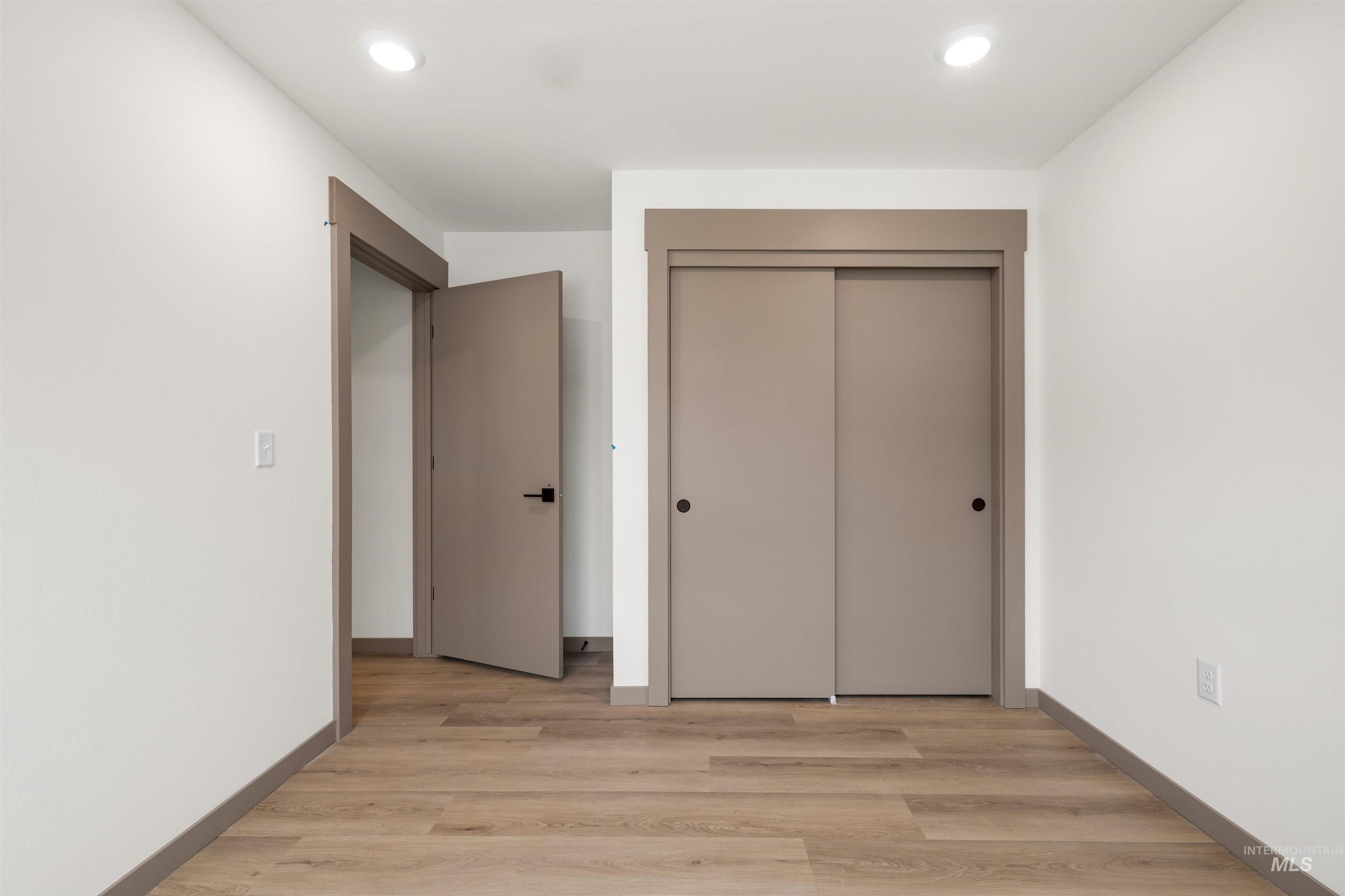 Unfurnished bedroom featuring a closet, light wood-style floors, and recessed lighting
