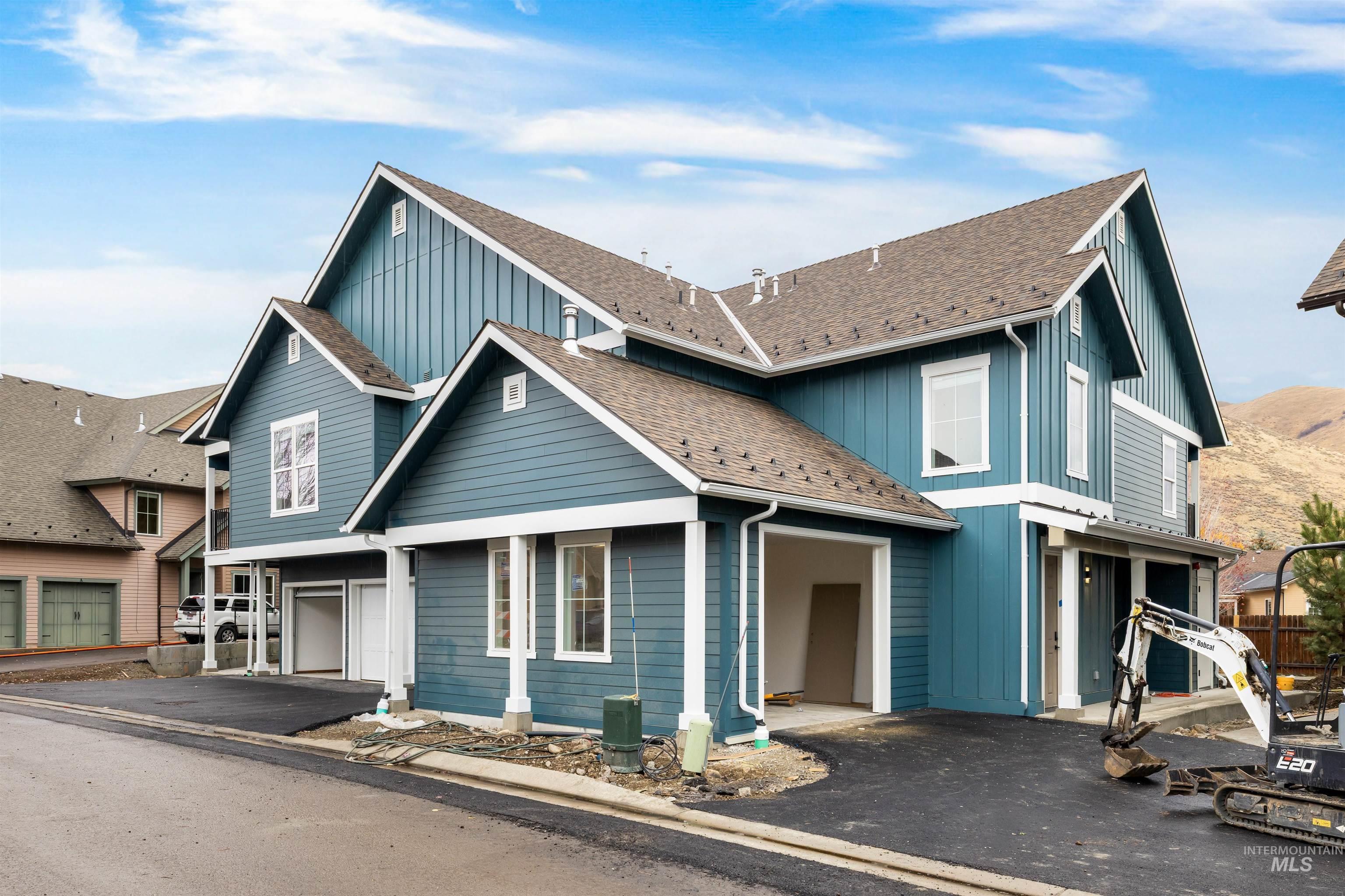 Traditional-style house featuring board and batten siding, driveway, an attached garage, and a shingled roof
