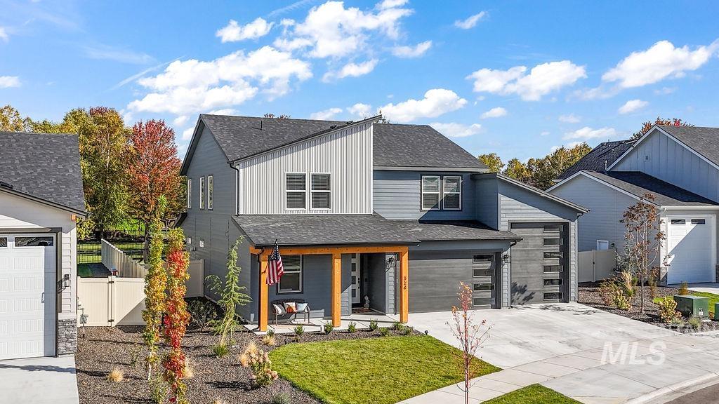 View of front of house featuring a porch, roof with shingles, concrete driveway, and board and batten siding