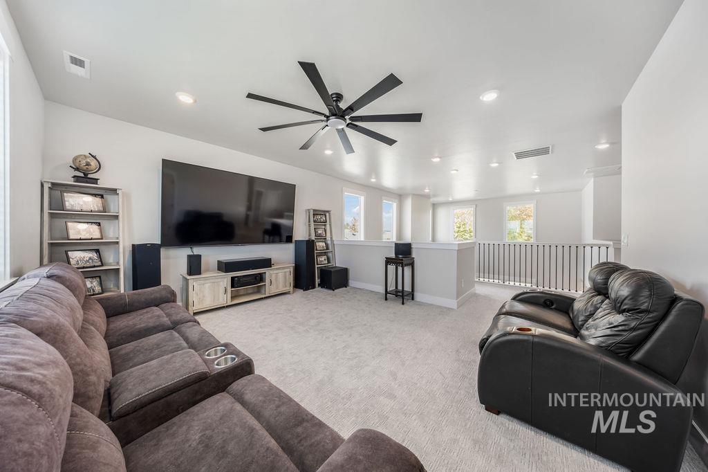 Living area with carpet floors, recessed lighting, and ceiling fan