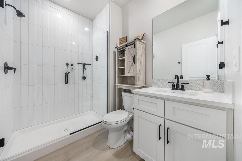 Bathroom with a stall shower, vanity, and light wood-type flooring