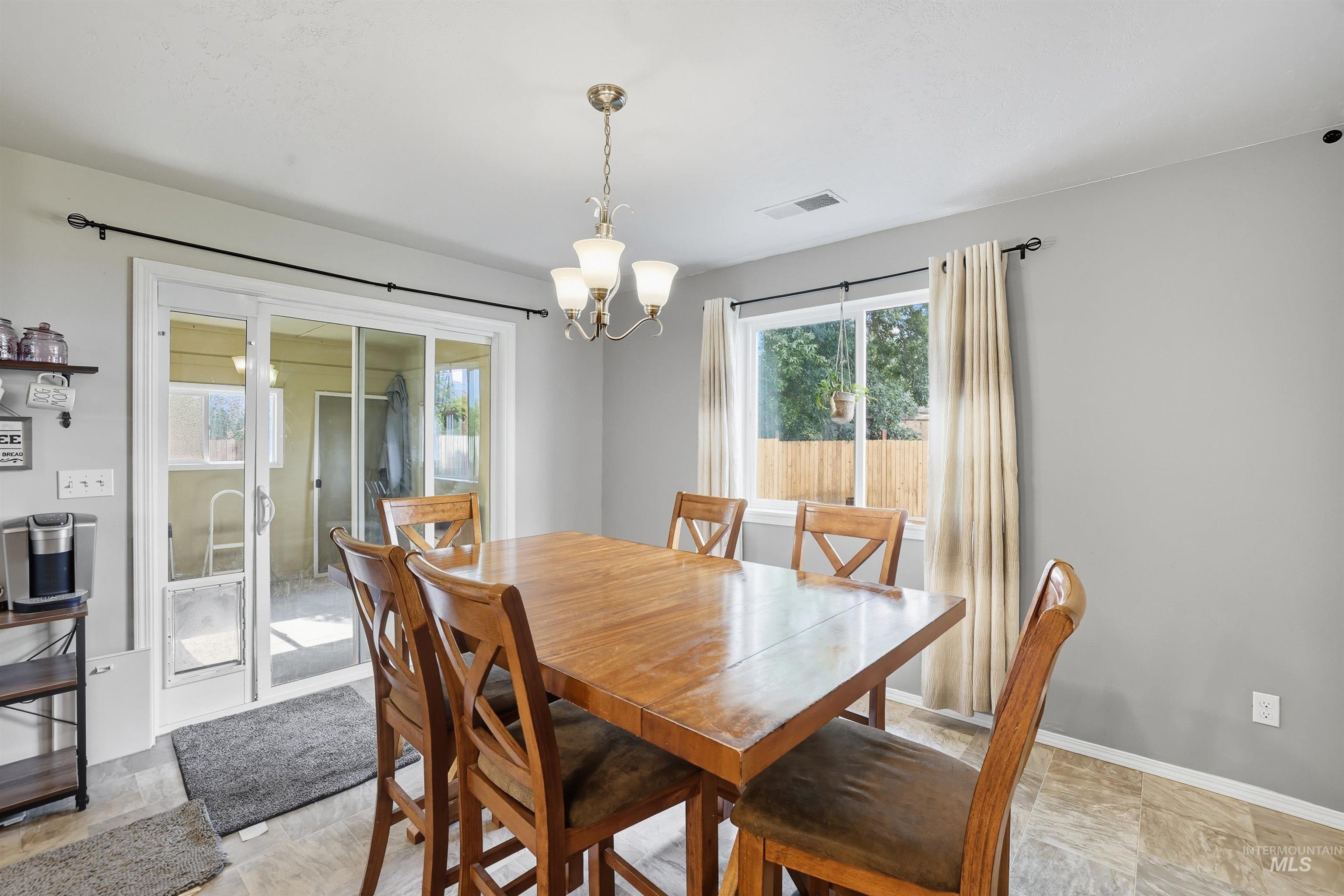 Dining room featuring a chandelier and baseboards