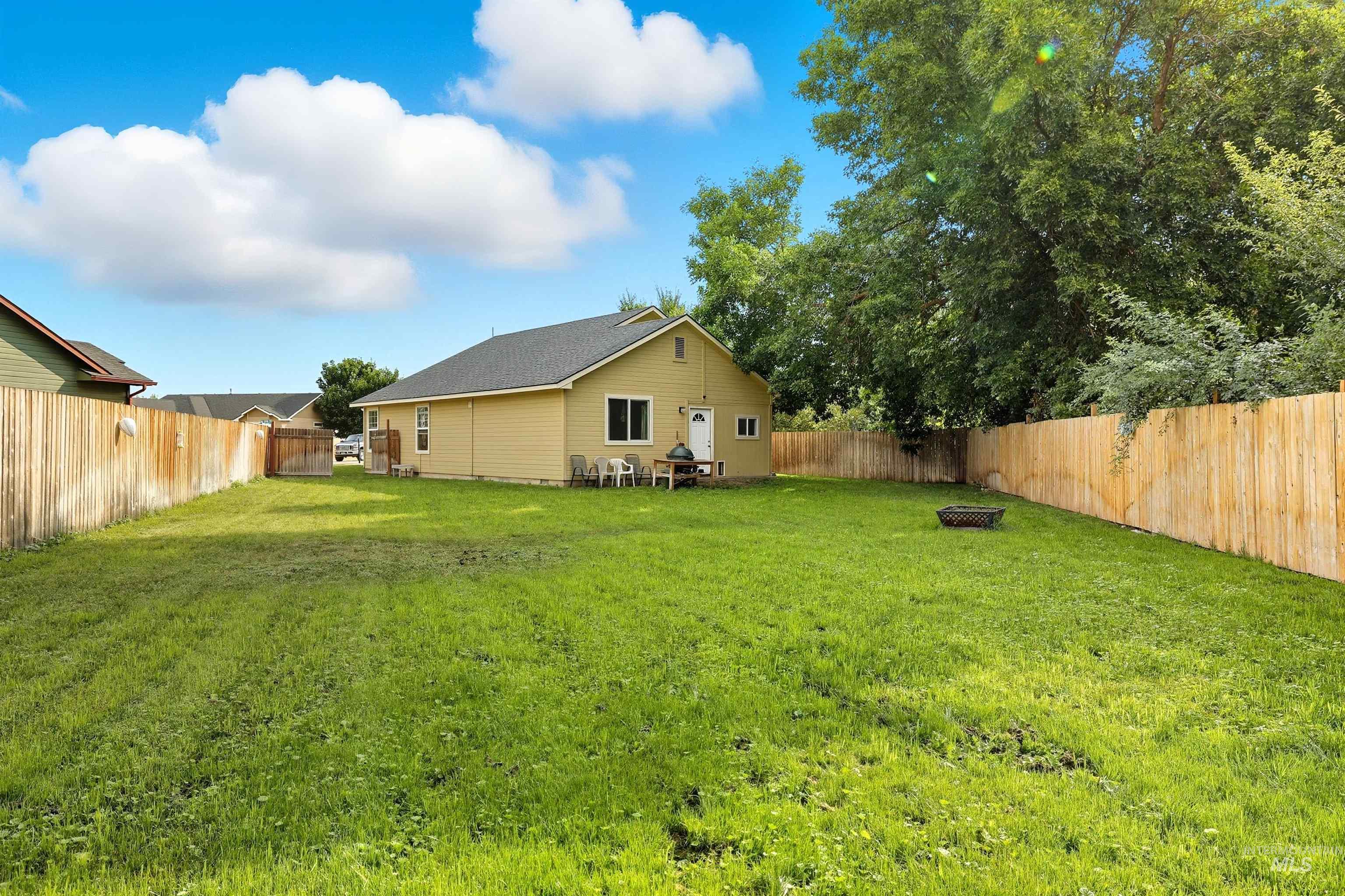 Fenced backyard featuring a fire pit