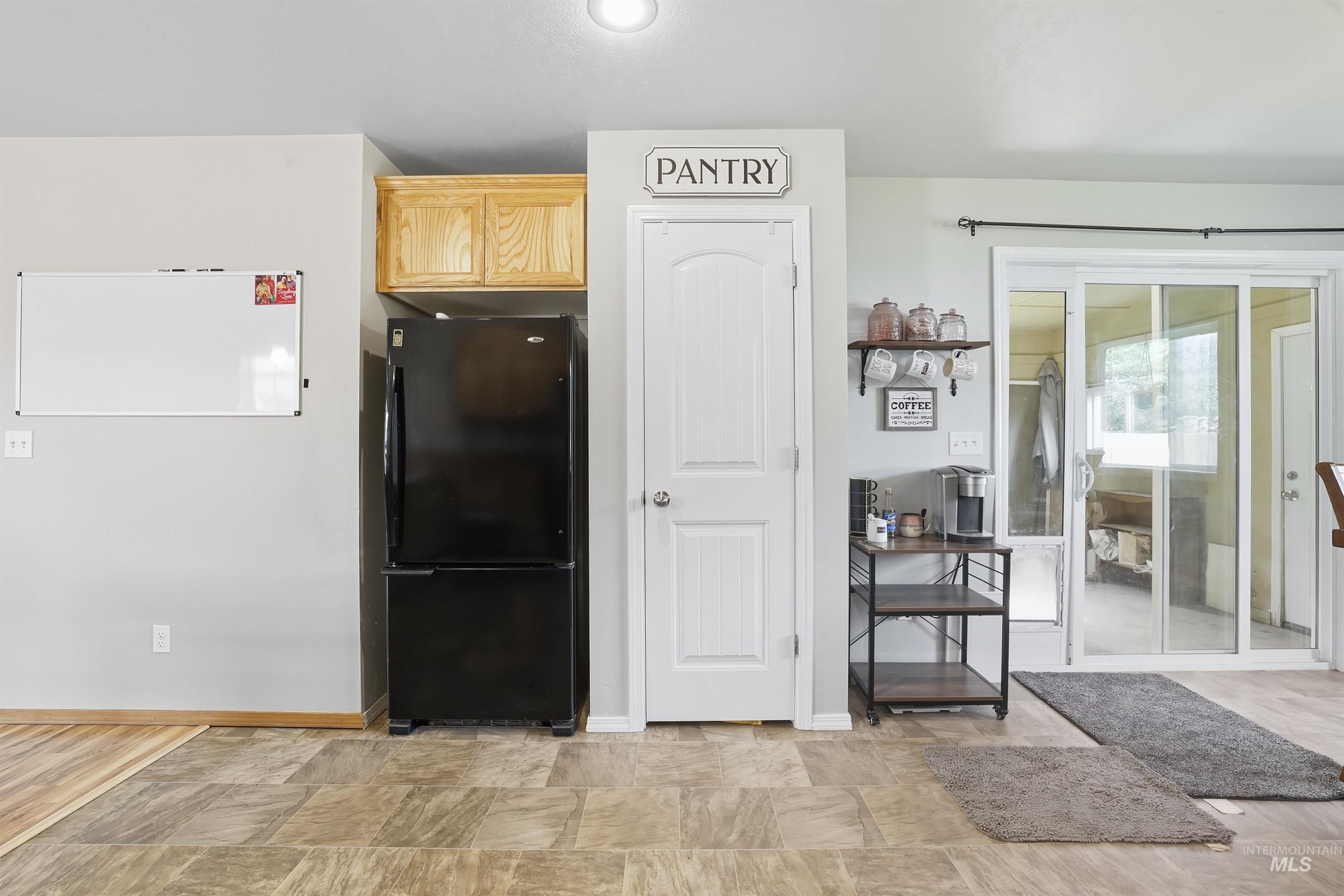 Kitchen featuring freestanding refrigerator and baseboards