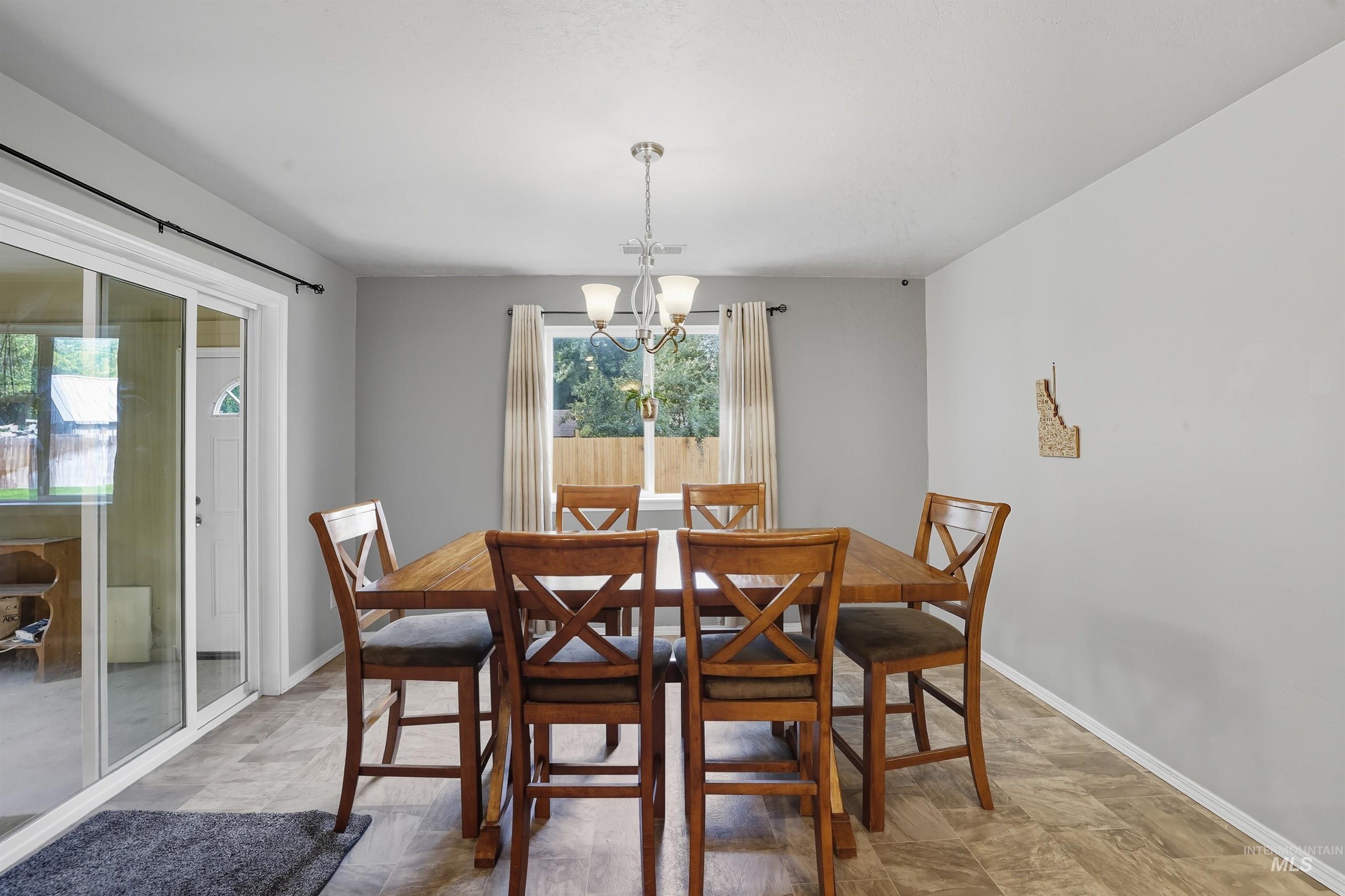 Dining space featuring a chandelier and baseboards