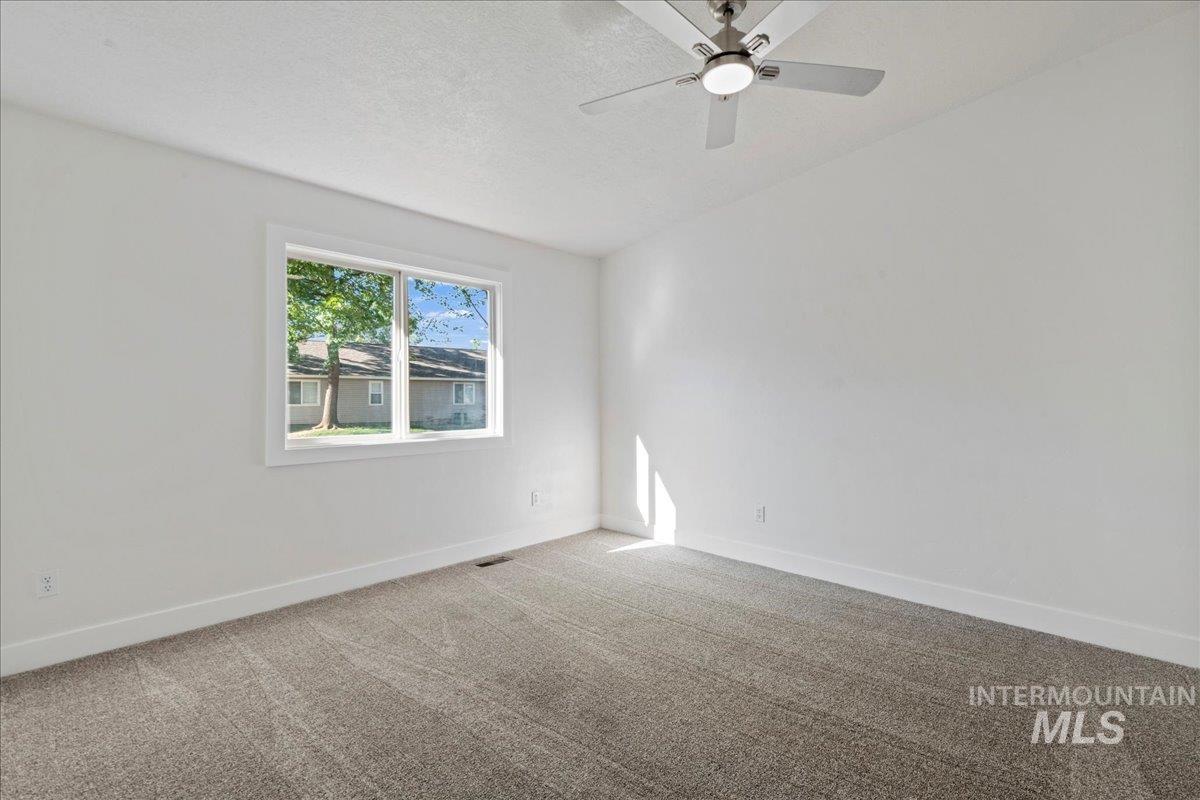 Primary Suite with carpet flooring, a textured ceiling, and ceiling fan