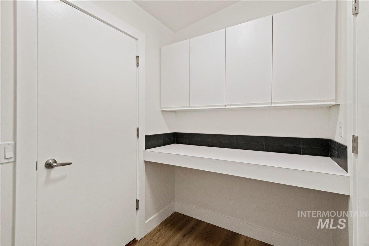 Laundry Room featuring dark wood-style flooring and baseboards