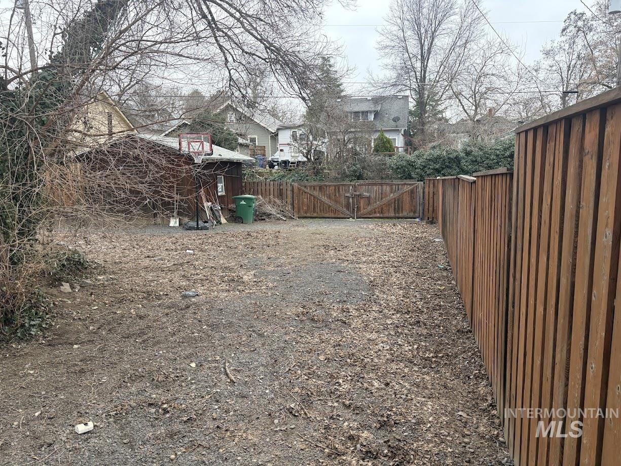 Fenced backyard with a gate and a residential view