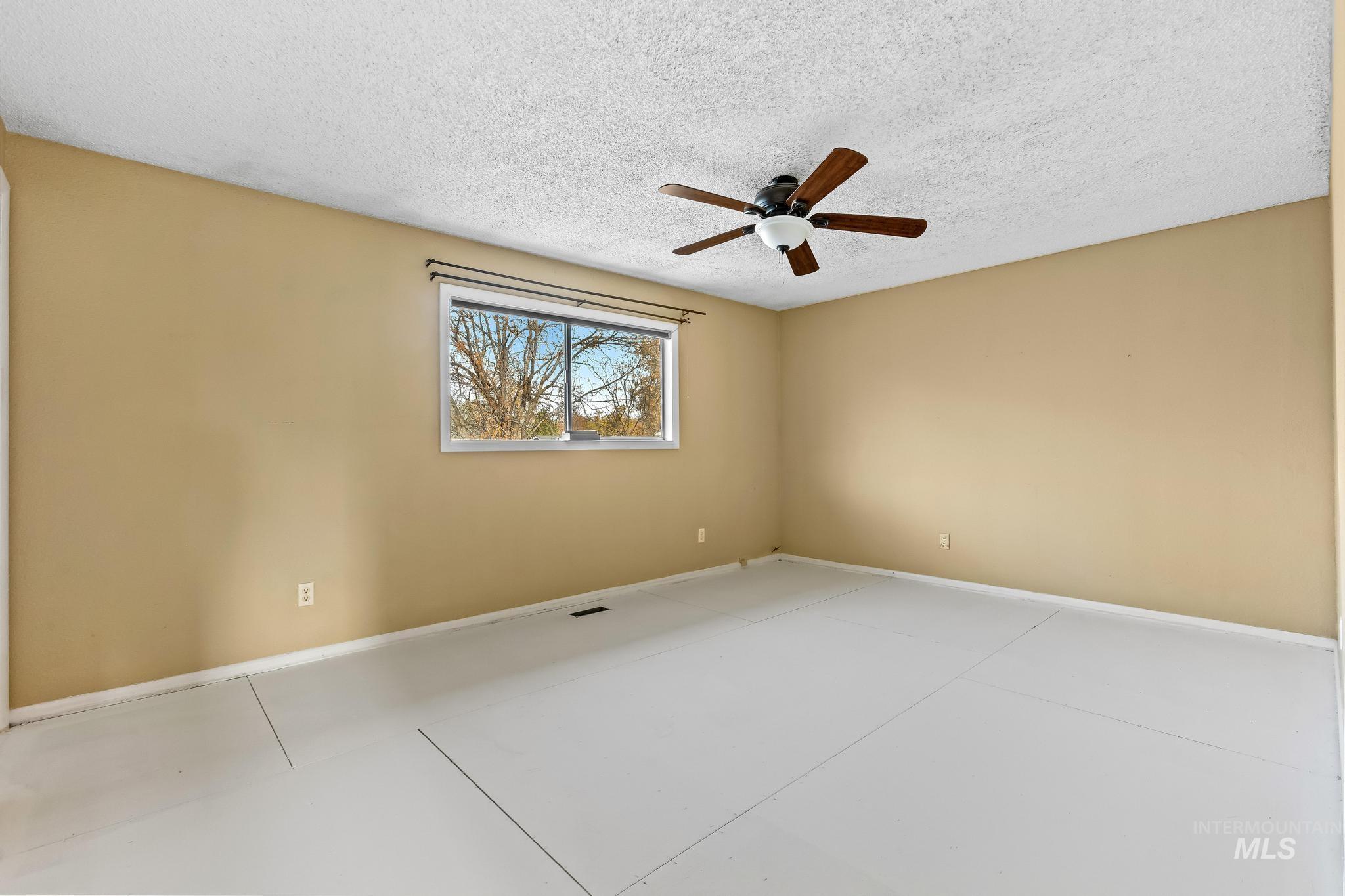 Empty room featuring a textured ceiling and ceiling fan