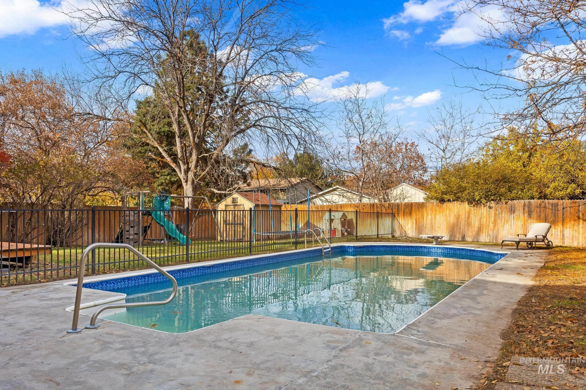 View of pool with a fenced backyard, a playground, and a patio