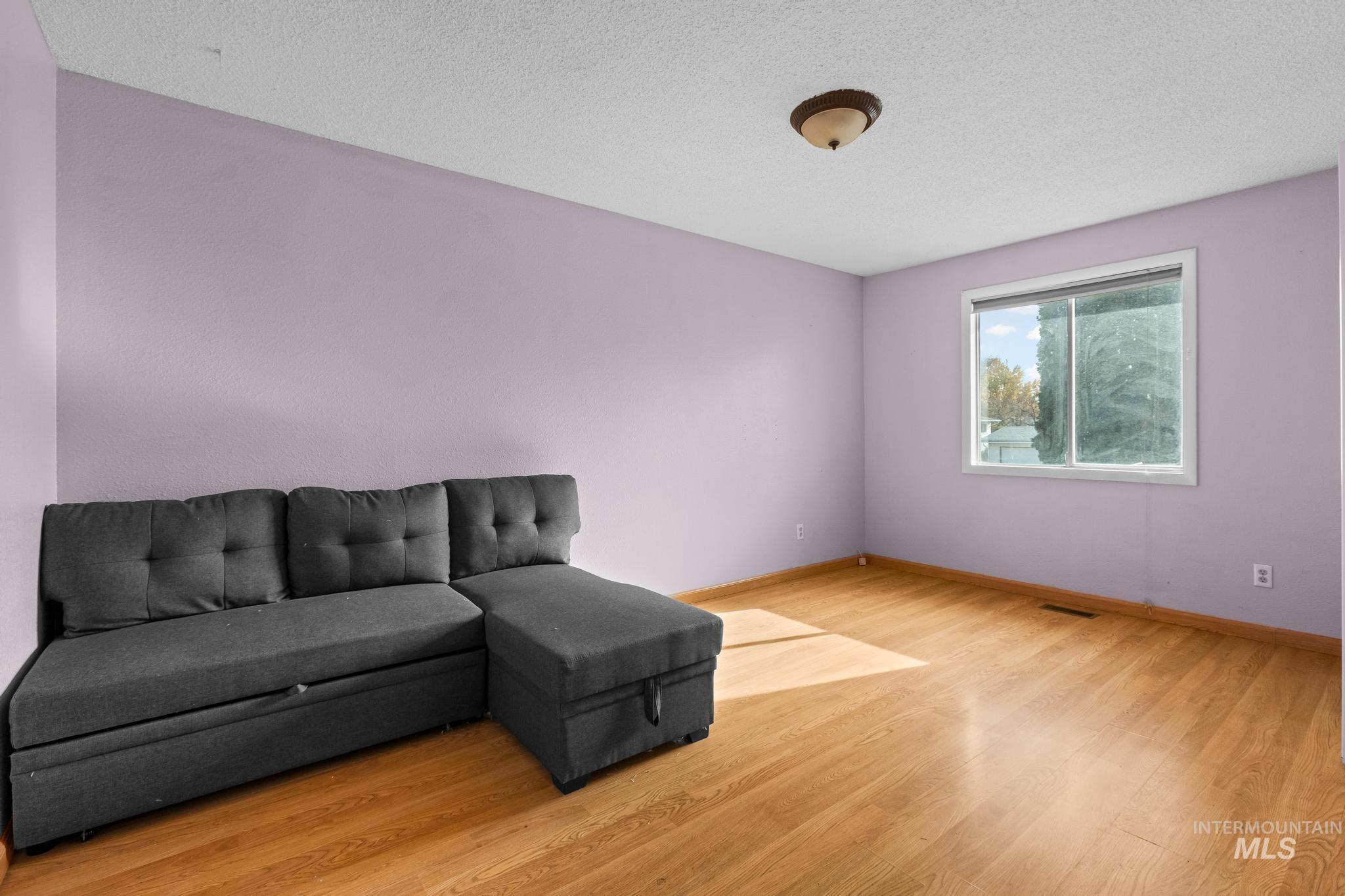 Living room featuring a textured ceiling and light wood finished floors