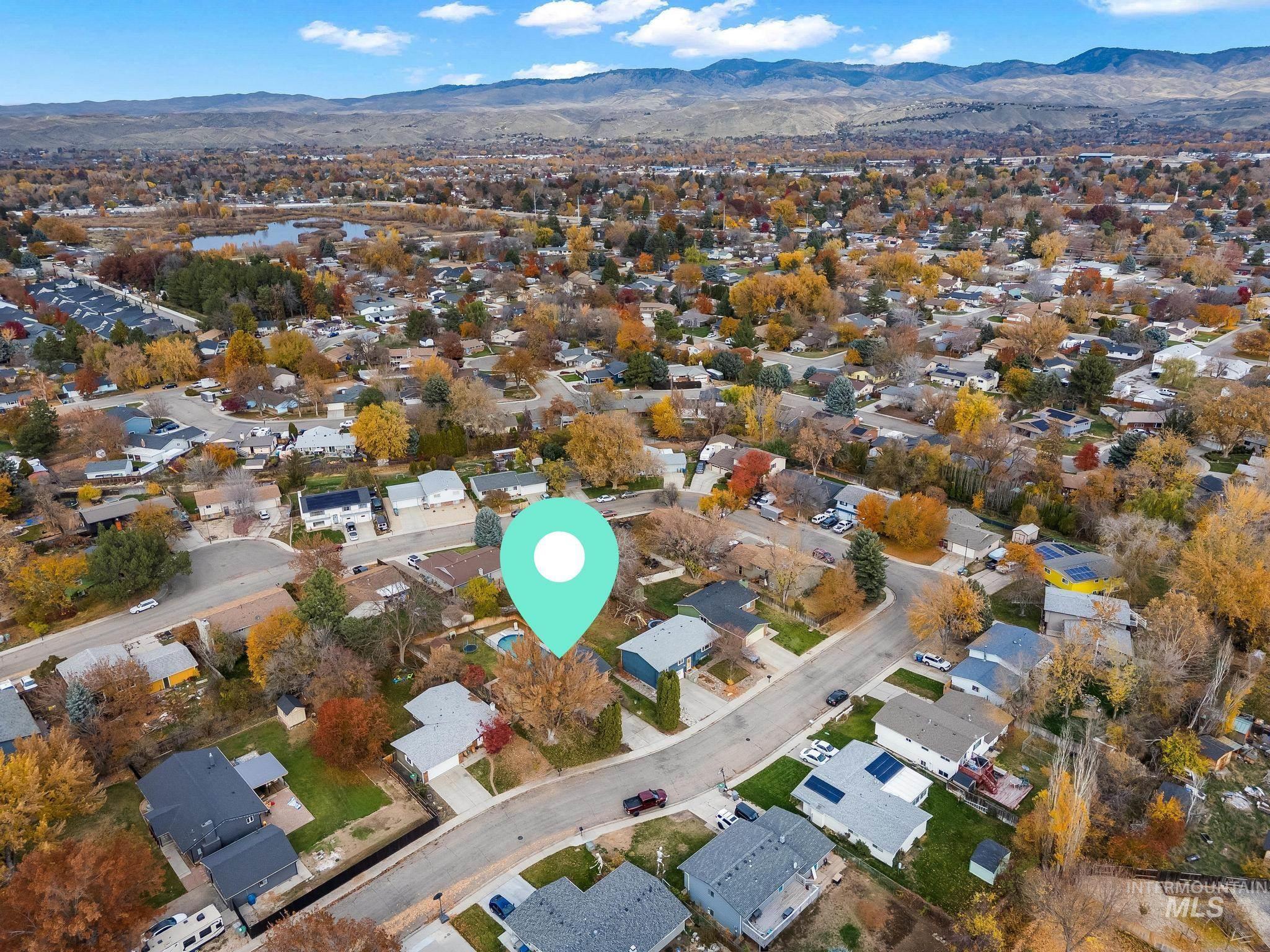 Aerial view of property and surrounding area featuring nearby suburban area and mountains