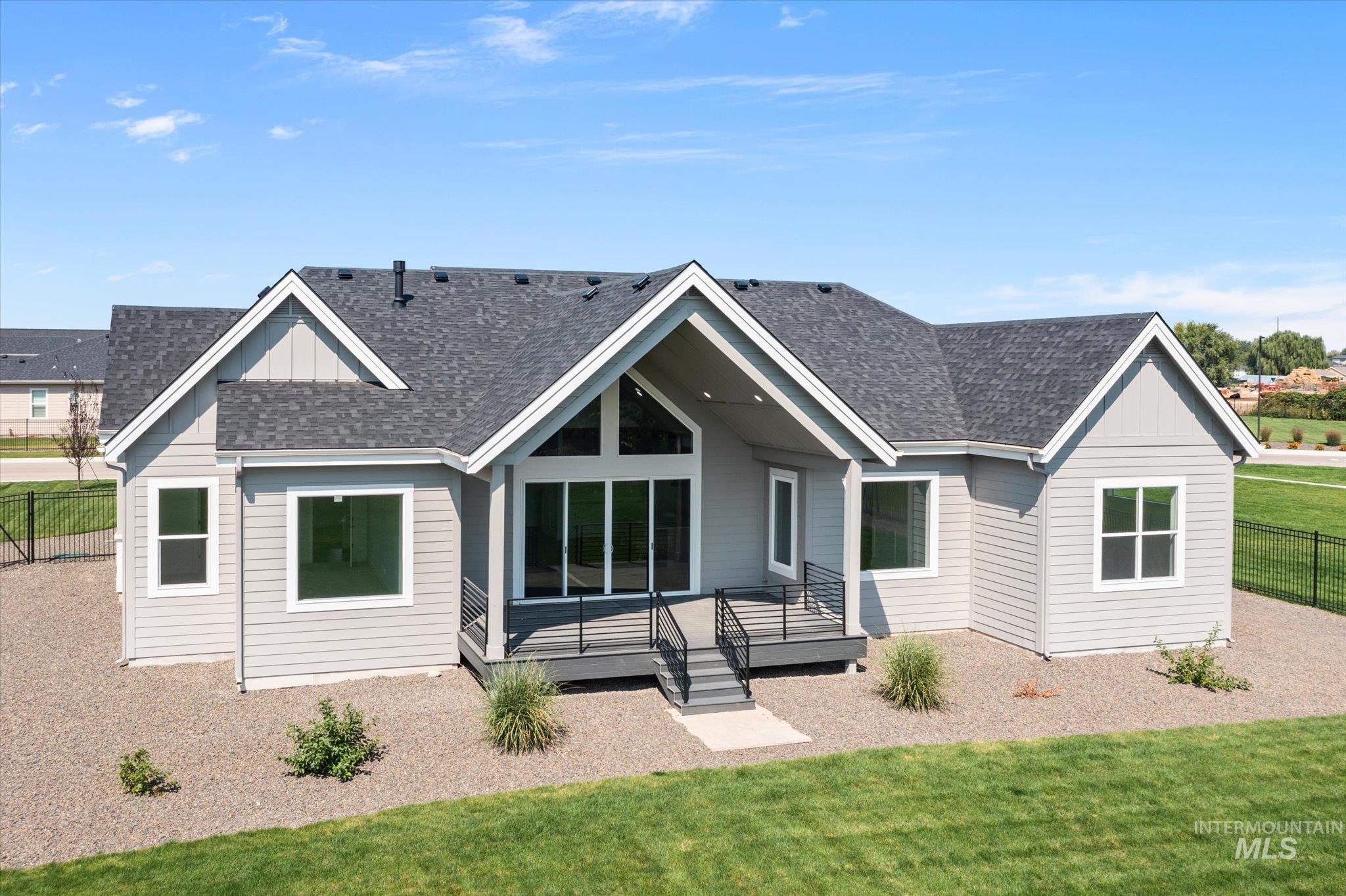 View of front of house featuring a shingled roof and a wooden deck
