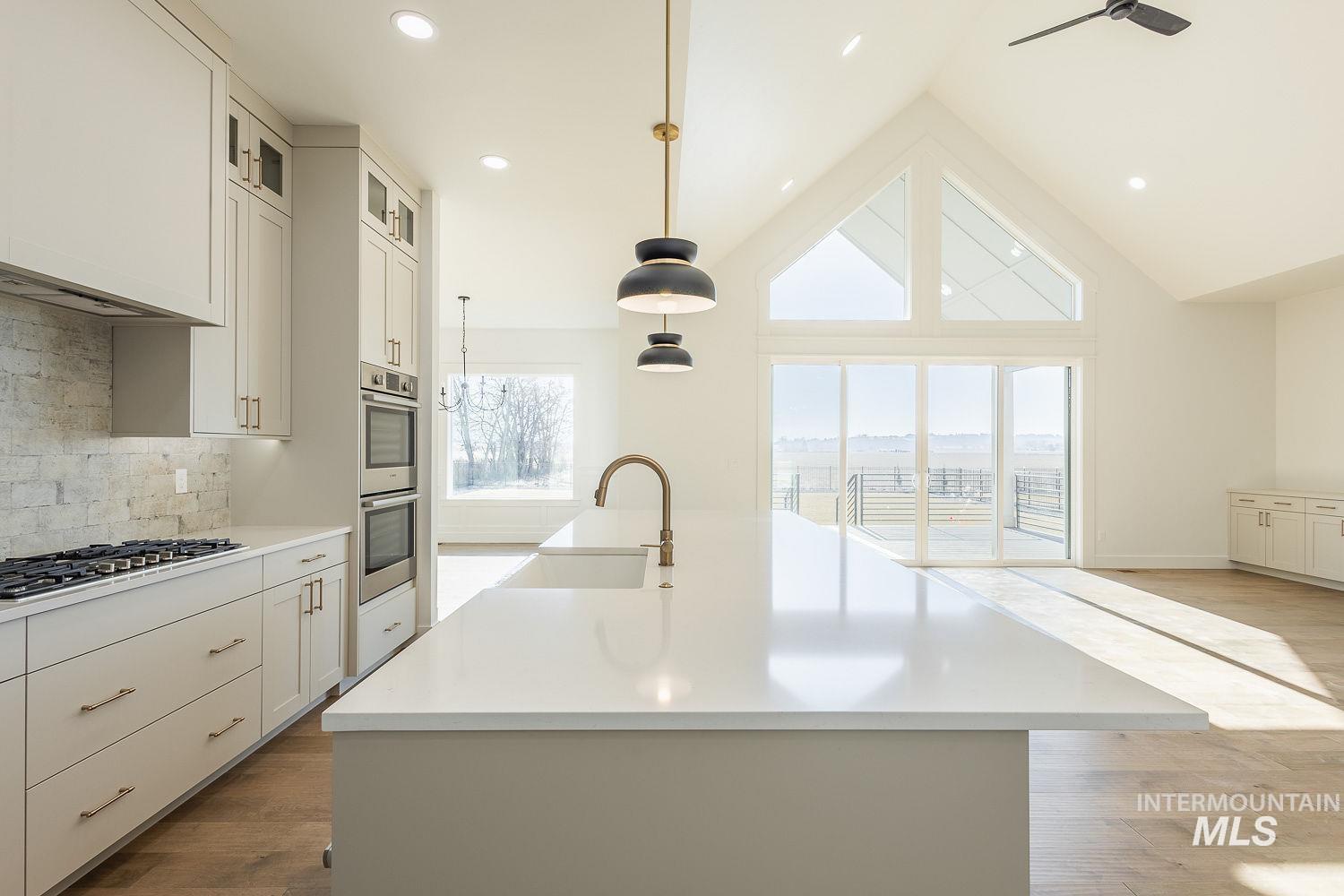 Kitchen featuring an island with sink, backsplash, hanging light fixtures, dark wood-type flooring, and recessed lighting