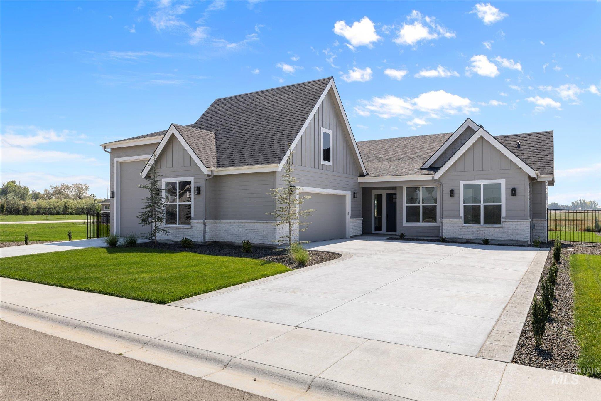 View of front of house featuring brick siding, a shingled roof, board and batten siding, and driveway