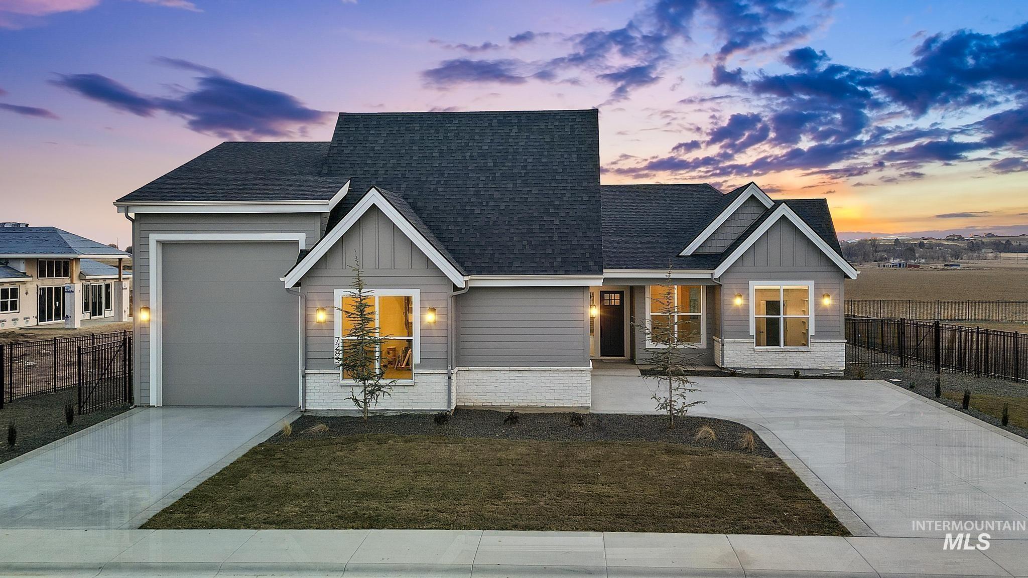 View of front facade featuring driveway, a garage, roof with shingles, and board and batten siding
