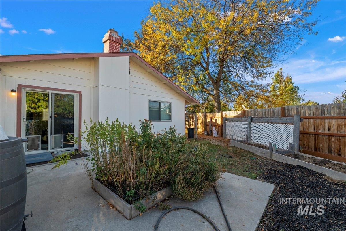 View of home's exterior featuring a fenced backyard and a chimney