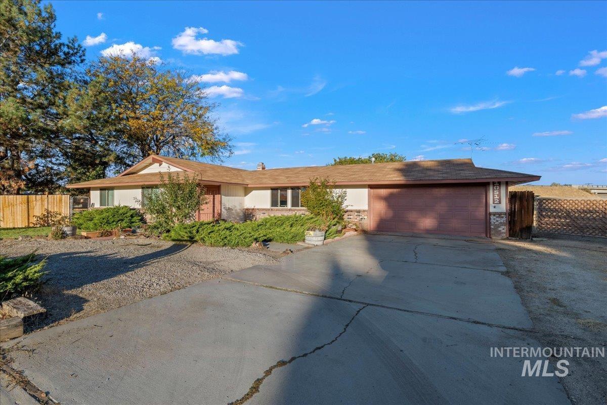 Single story home with concrete driveway and a garage