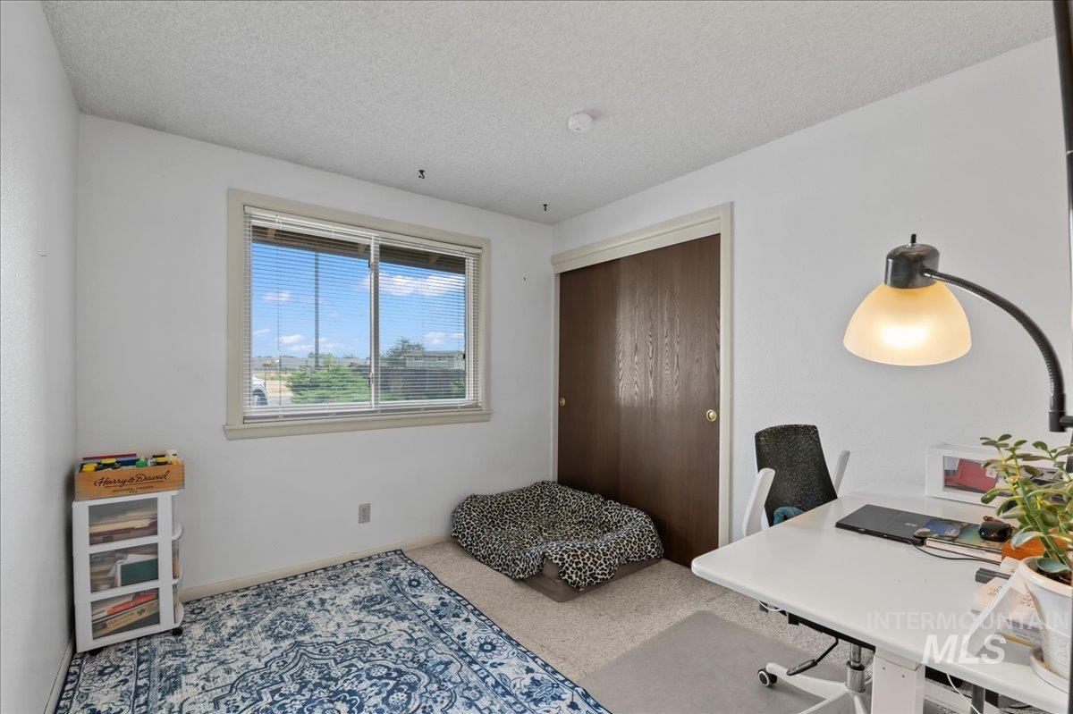 Office with a textured ceiling and carpet floors