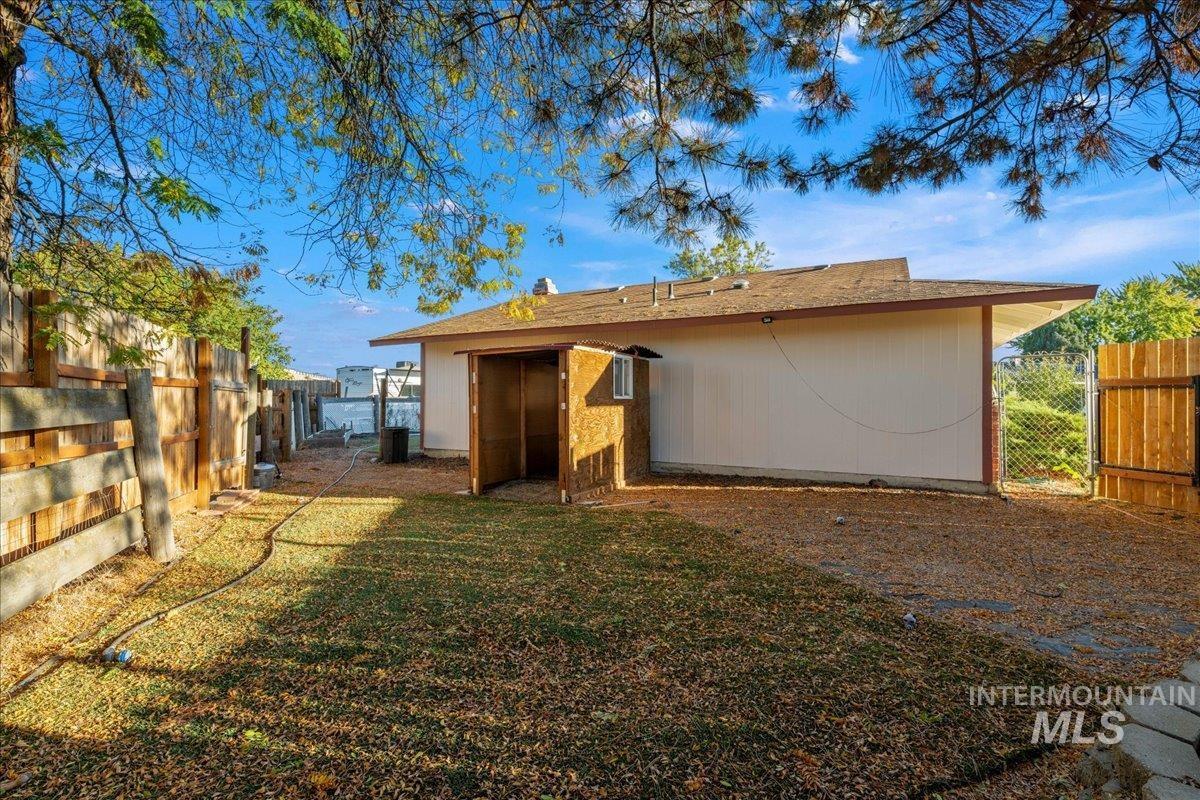 Rear view of property with a fenced backyard and a shingled roof