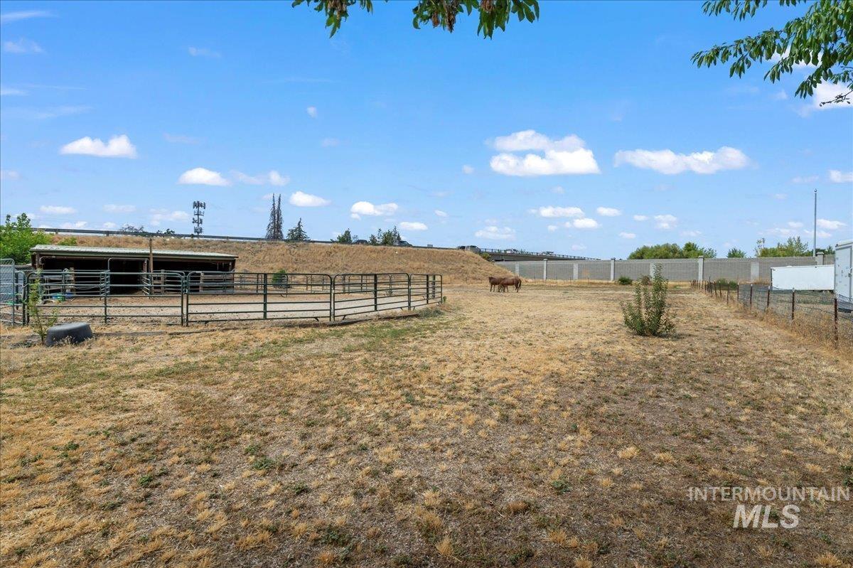 View of yard featuring a view of countryside, an outdoor structure, and an exterior structure