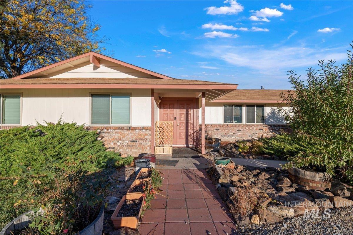 Ranch-style home featuring brick siding and roof with shingles