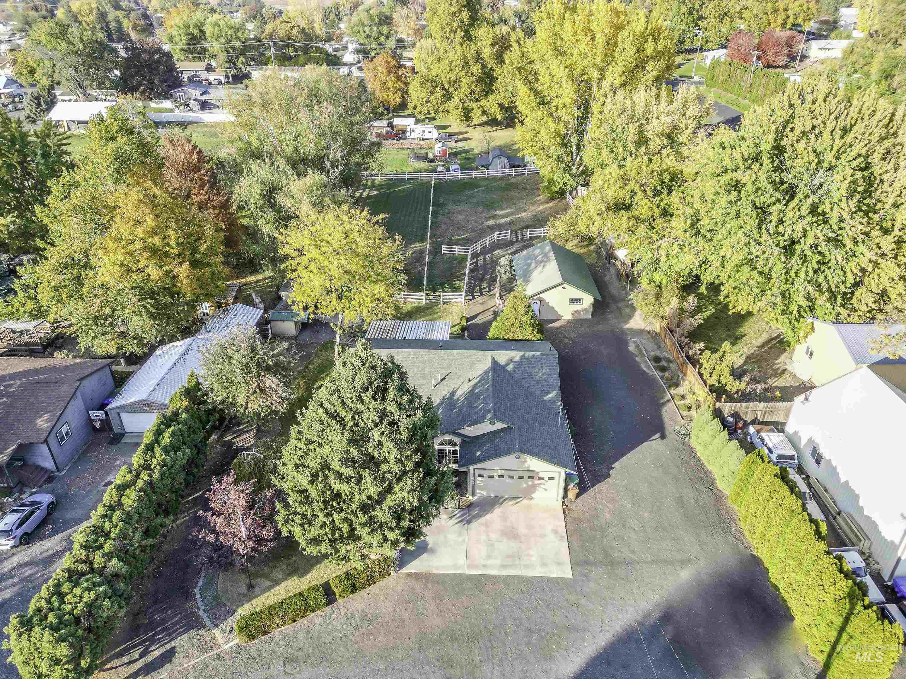 Aerial overview of property's location featuring nearby suburban area and a tree filled landscape