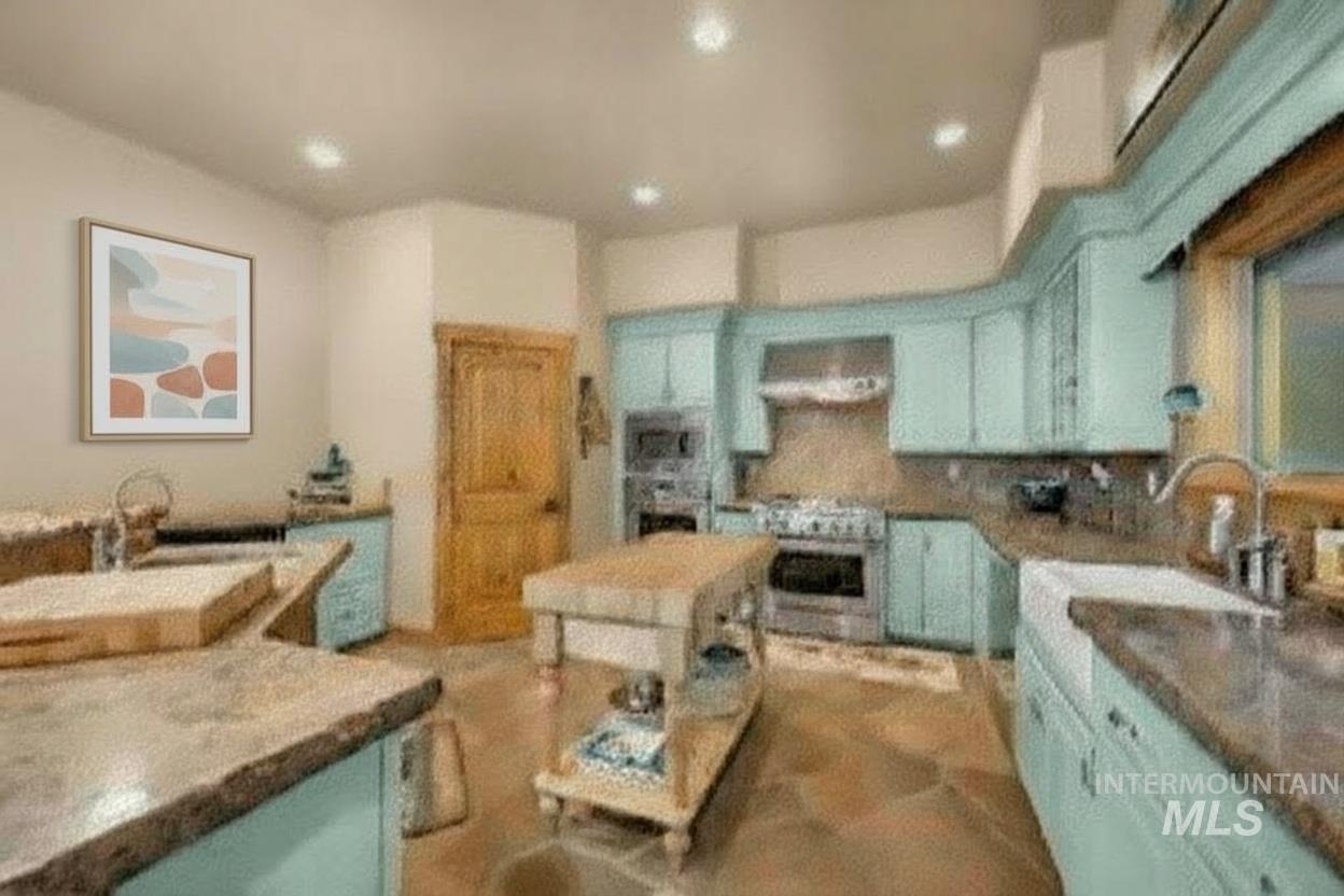 Kitchen featuring blue cabinetry, backsplash, and recessed lighting