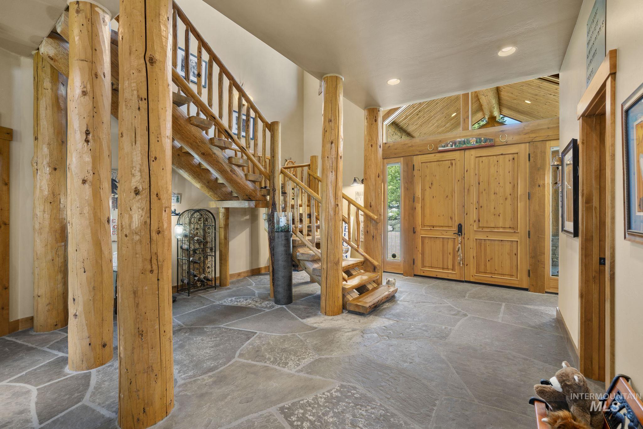 Entryway with stone floors, recessed lighting, stairway, and vaulted ceiling
