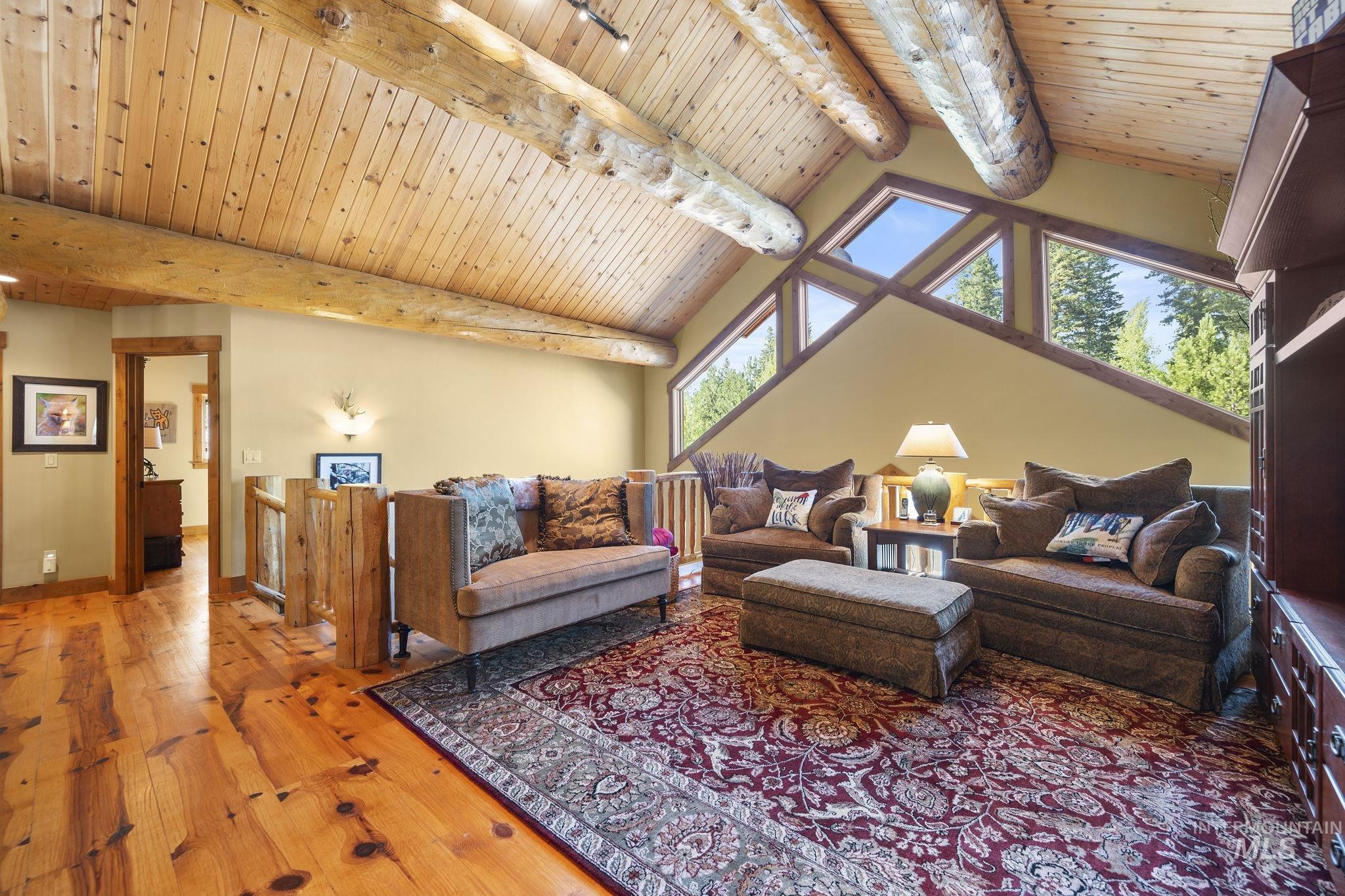 Living area featuring hardwood / wood-style floors and a wood ceiling with exposed beams