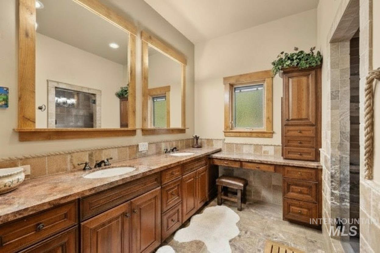 Bathroom with double vanity, a shower, and recessed lighting