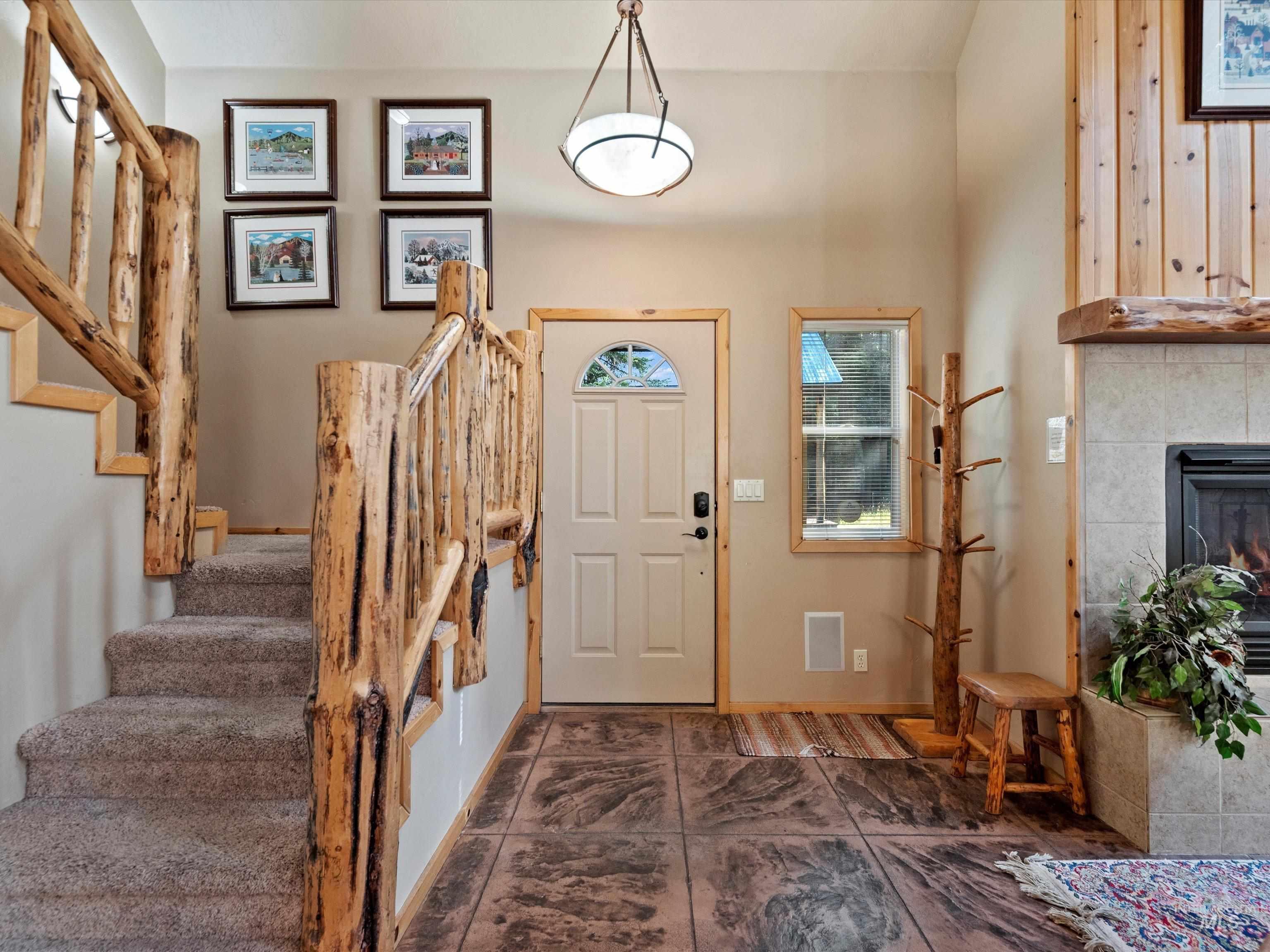 Foyer with stairs and a tile fireplace