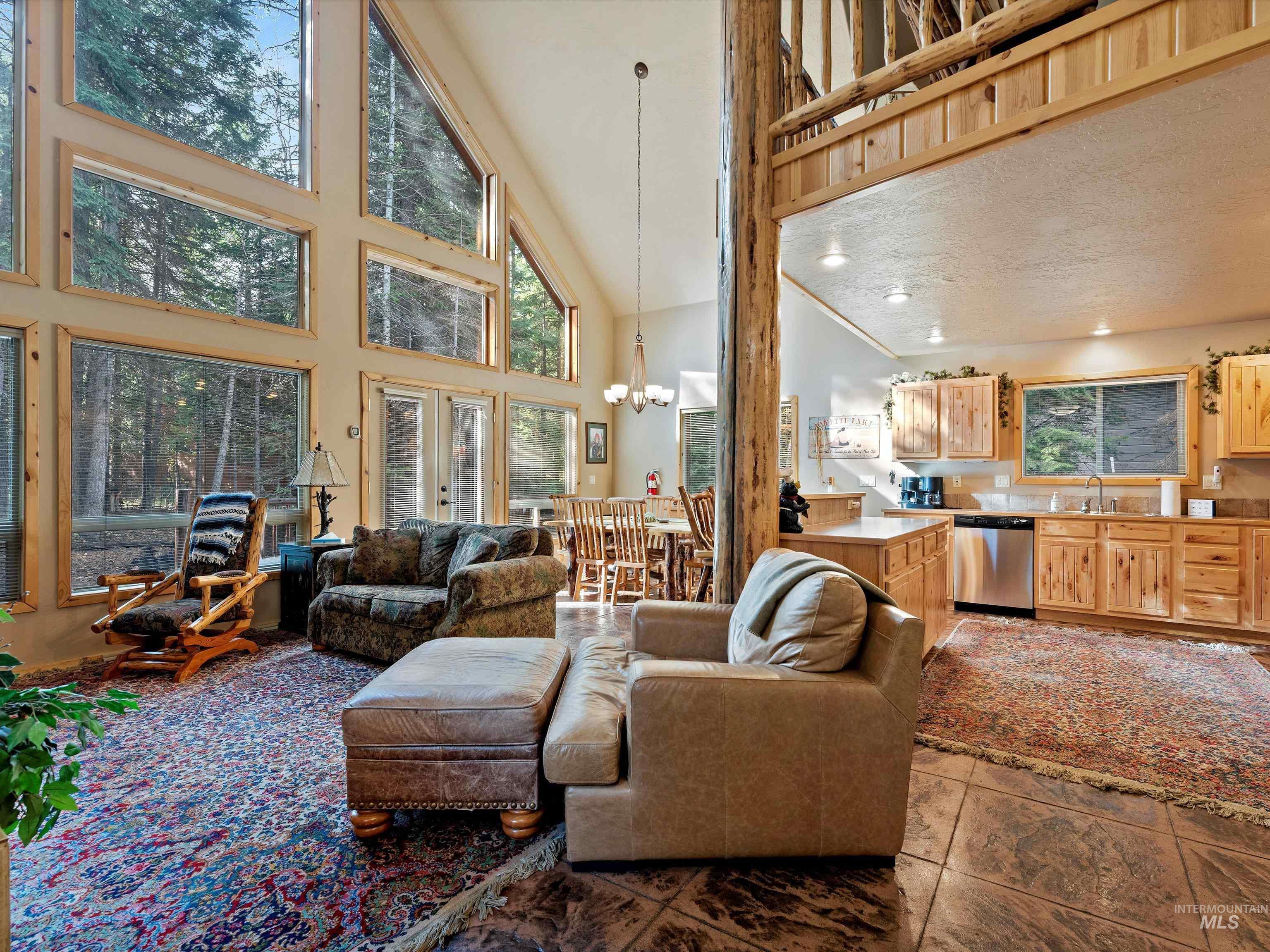 Living room featuring hanging lights, french doors, and vaulted ceiling
