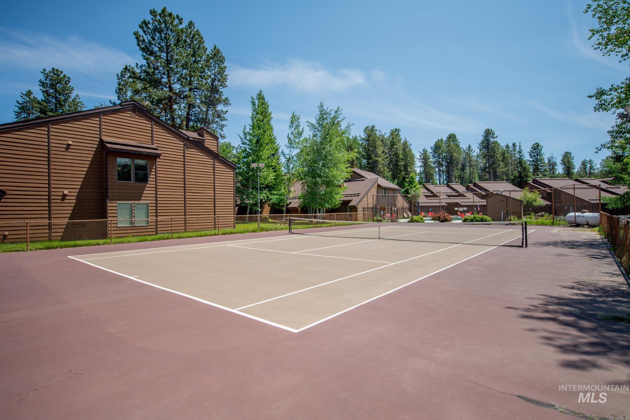 View of tennis court featuring community basketball court and a residential view