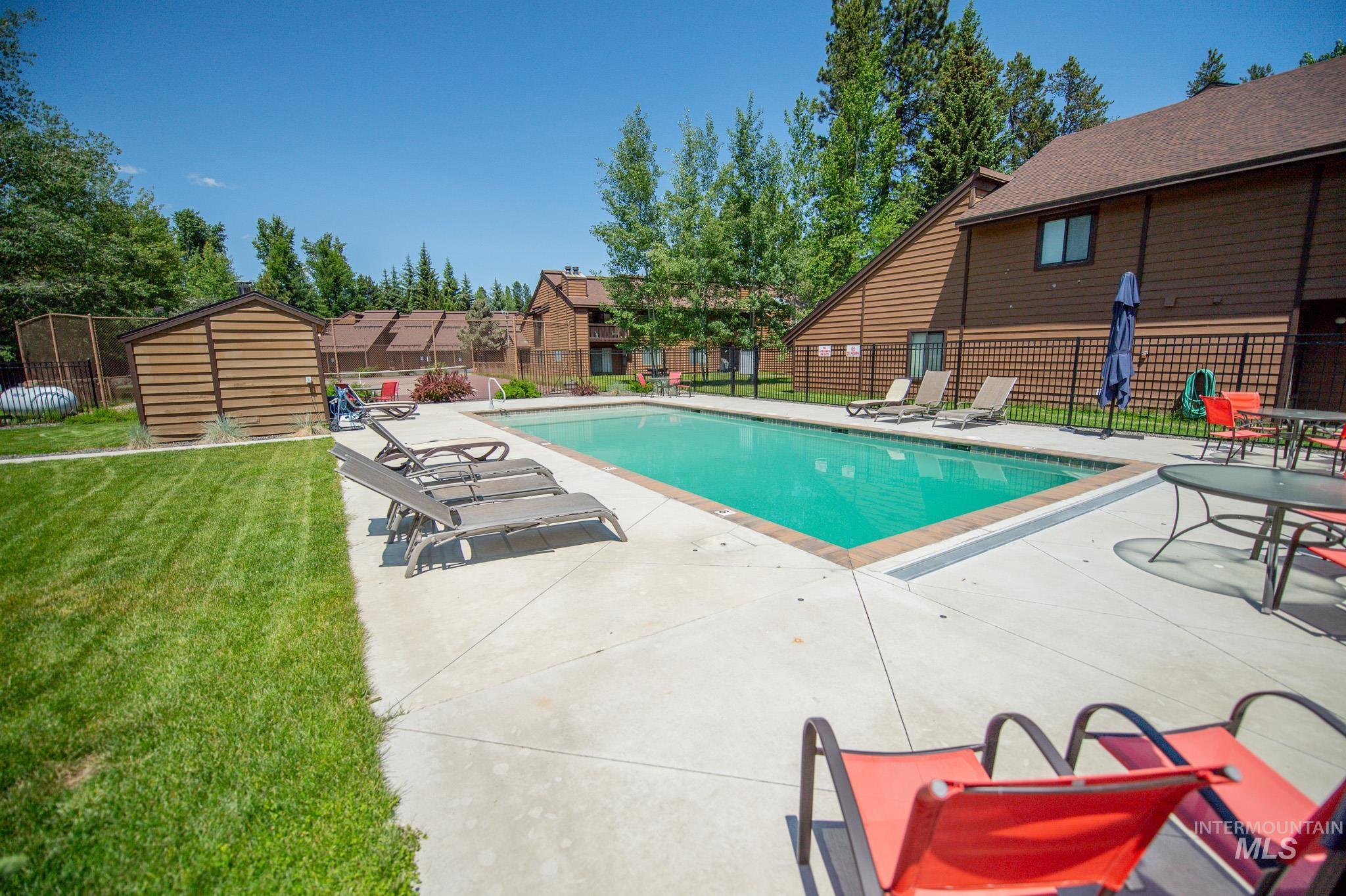 Community pool featuring a patio and a storage shed