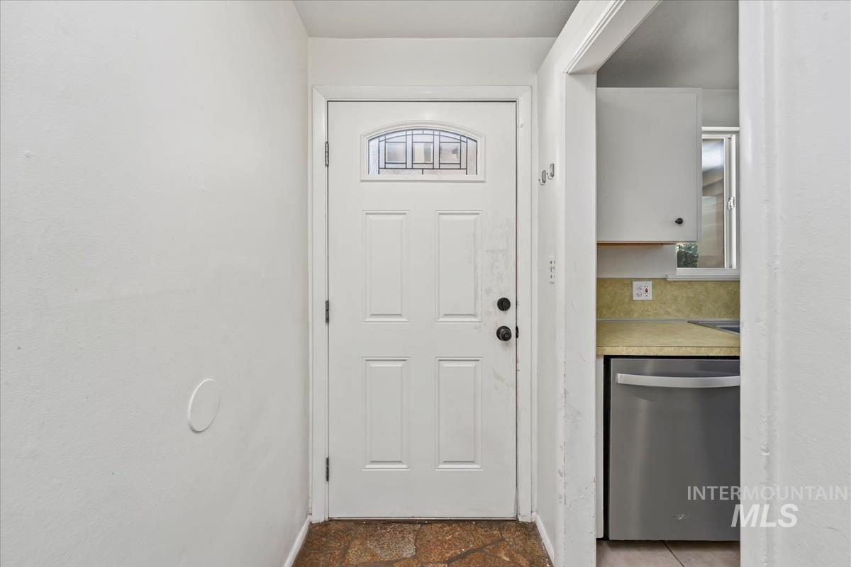 Entry door with decorative glass insert, paneled design, and black hardware