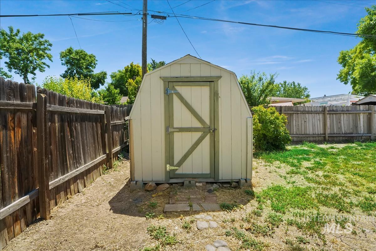 Detached storage shed with a gambrel roof and a single entry door