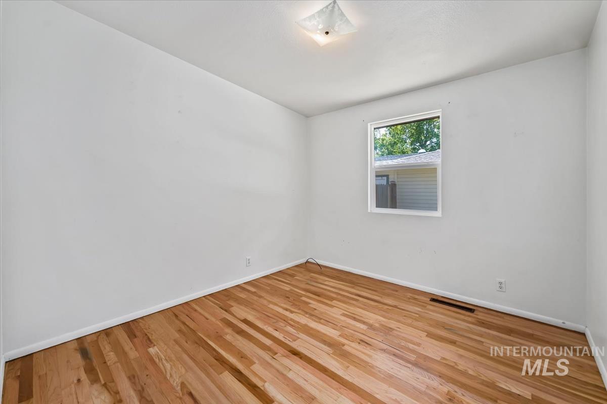 Room featuring hardwood flooring and white walls