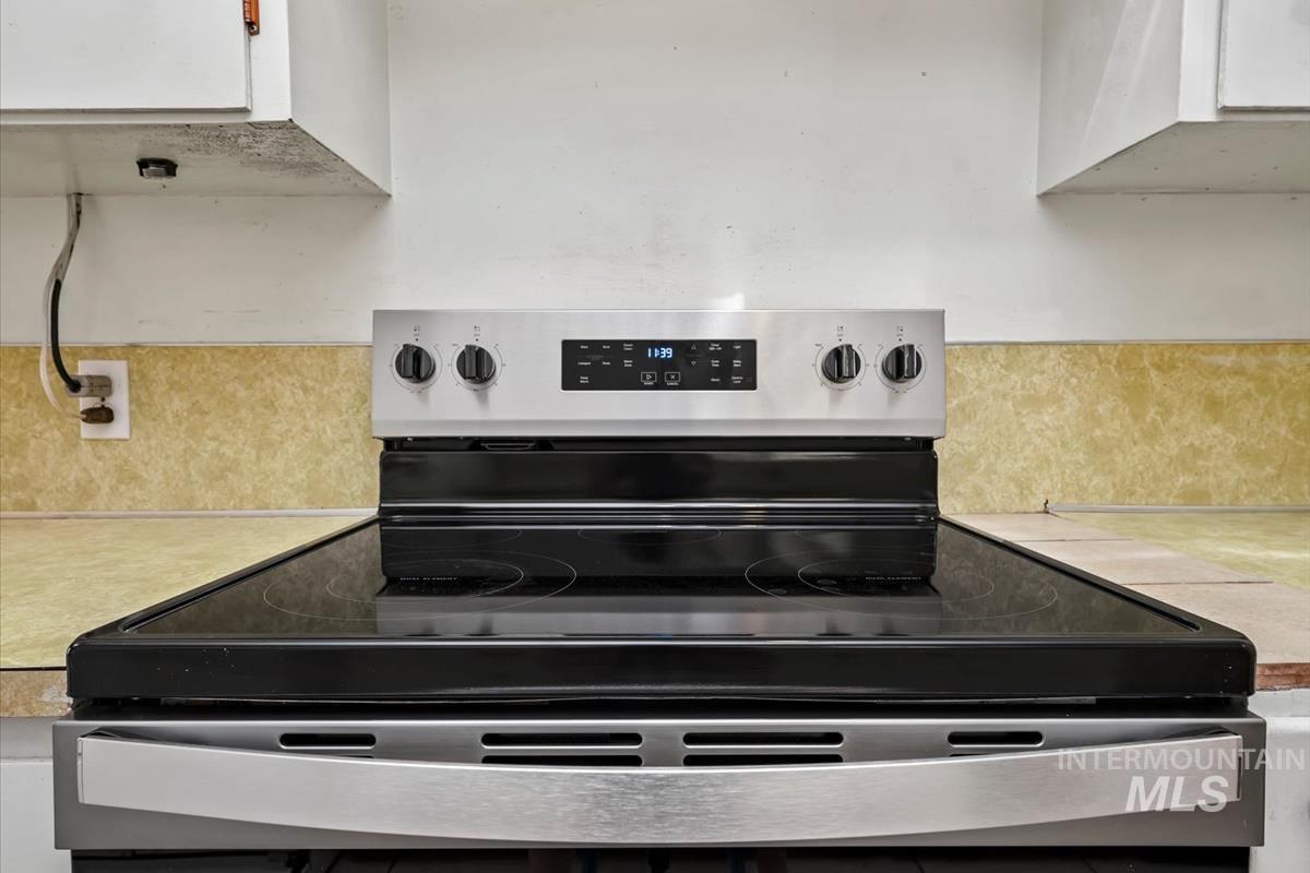 Stainless steel range with a black glass cooktop and digital controls