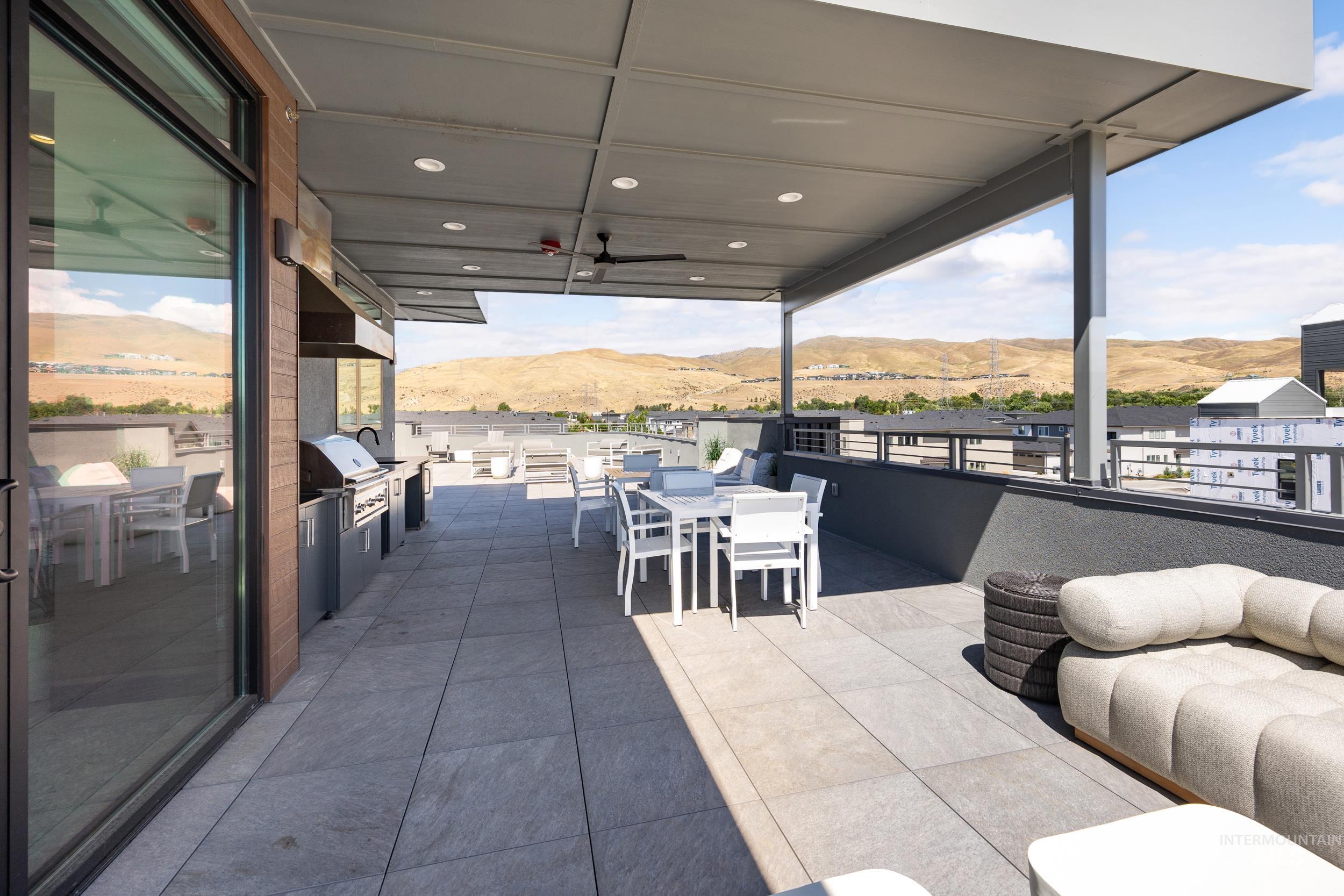 View of patio with a mountain view, outdoor dining area, area for grilling, and ceiling fan