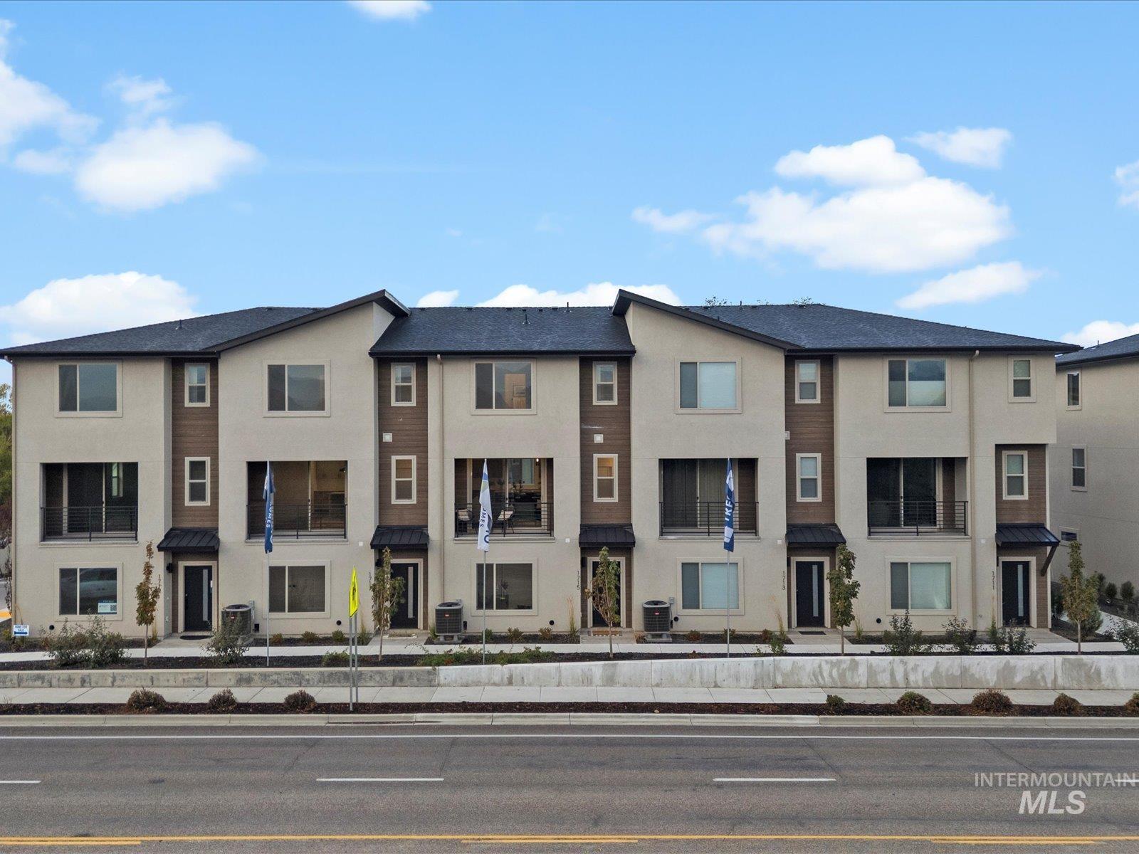 View of front of house with stucco siding, a residential view, a metal roof, and a standing seam roof