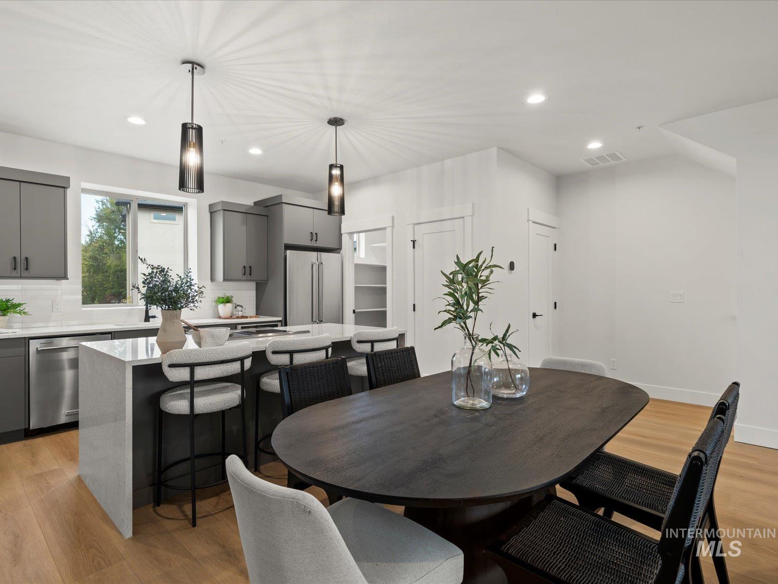 Dining area with light wood-type flooring and recessed lighting