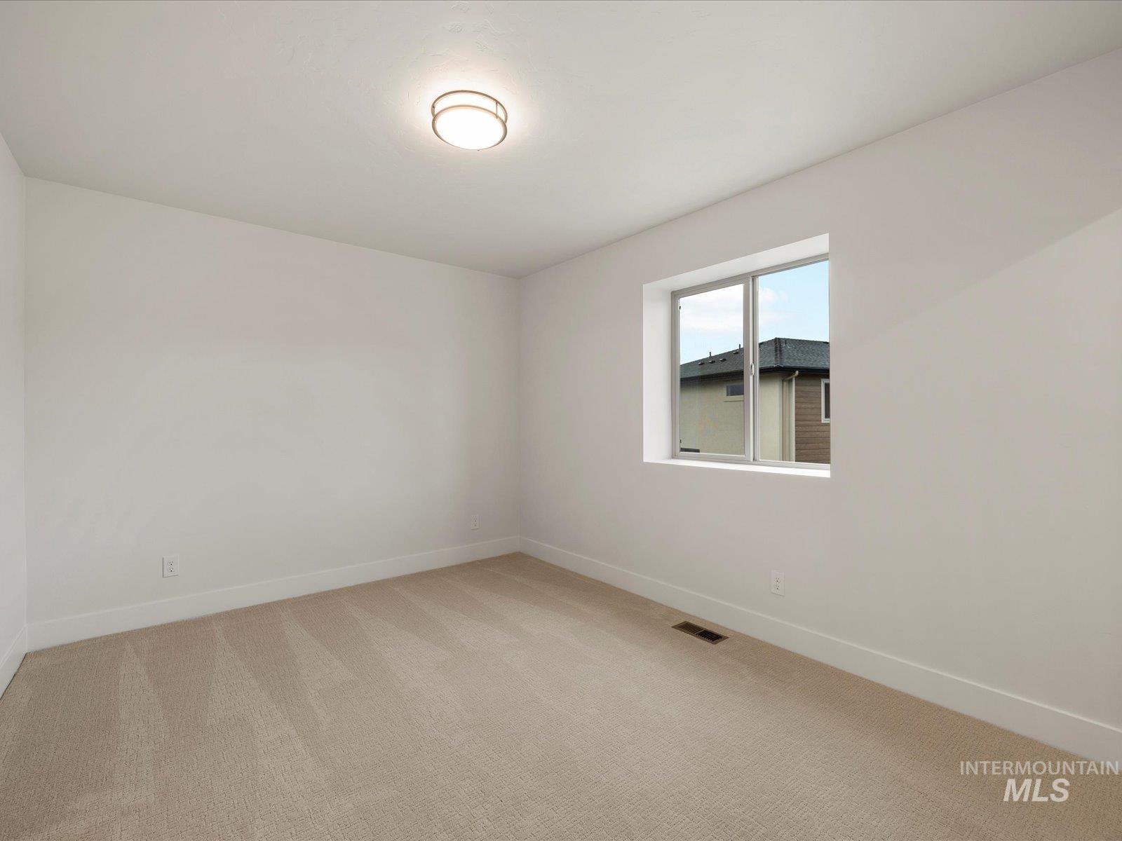 Unfurnished room featuring light carpet and baseboards