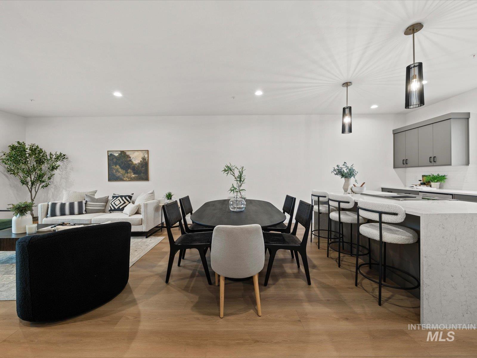 Dining area with light wood finished floors and recessed lighting