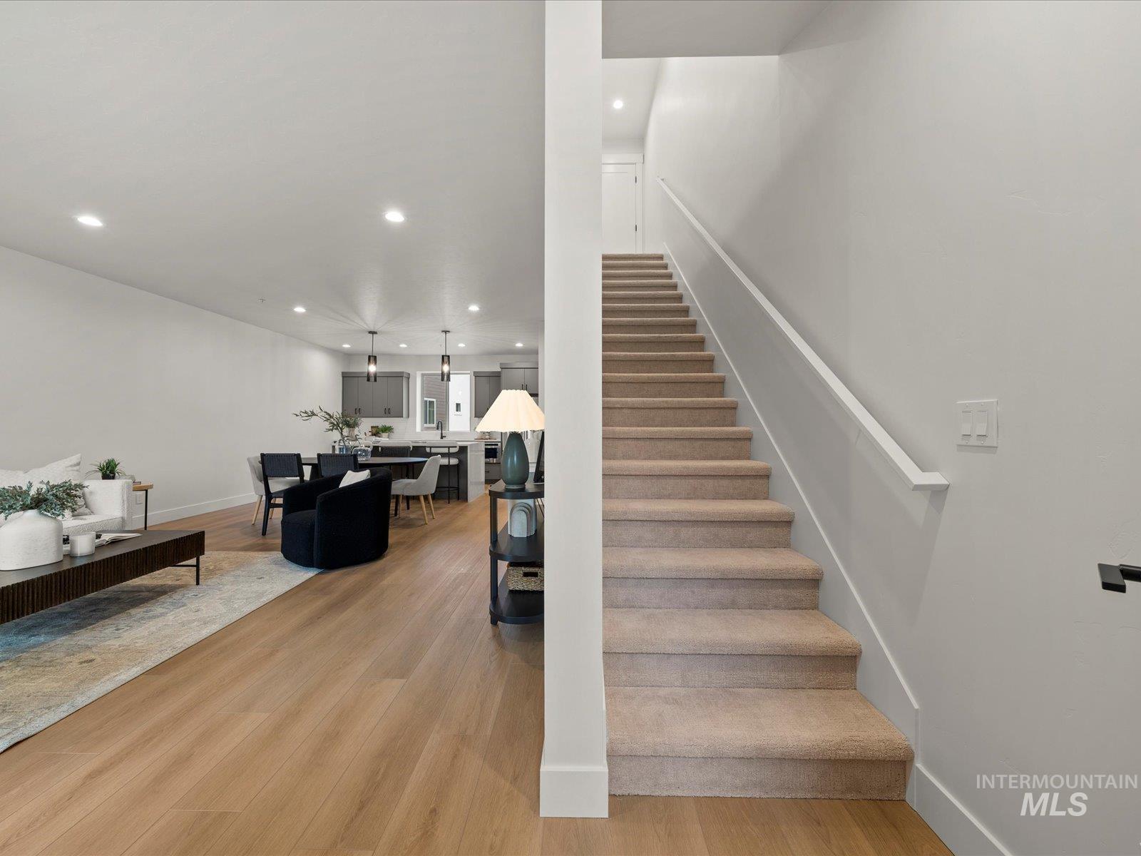 Stairs featuring wood finished floors and recessed lighting
