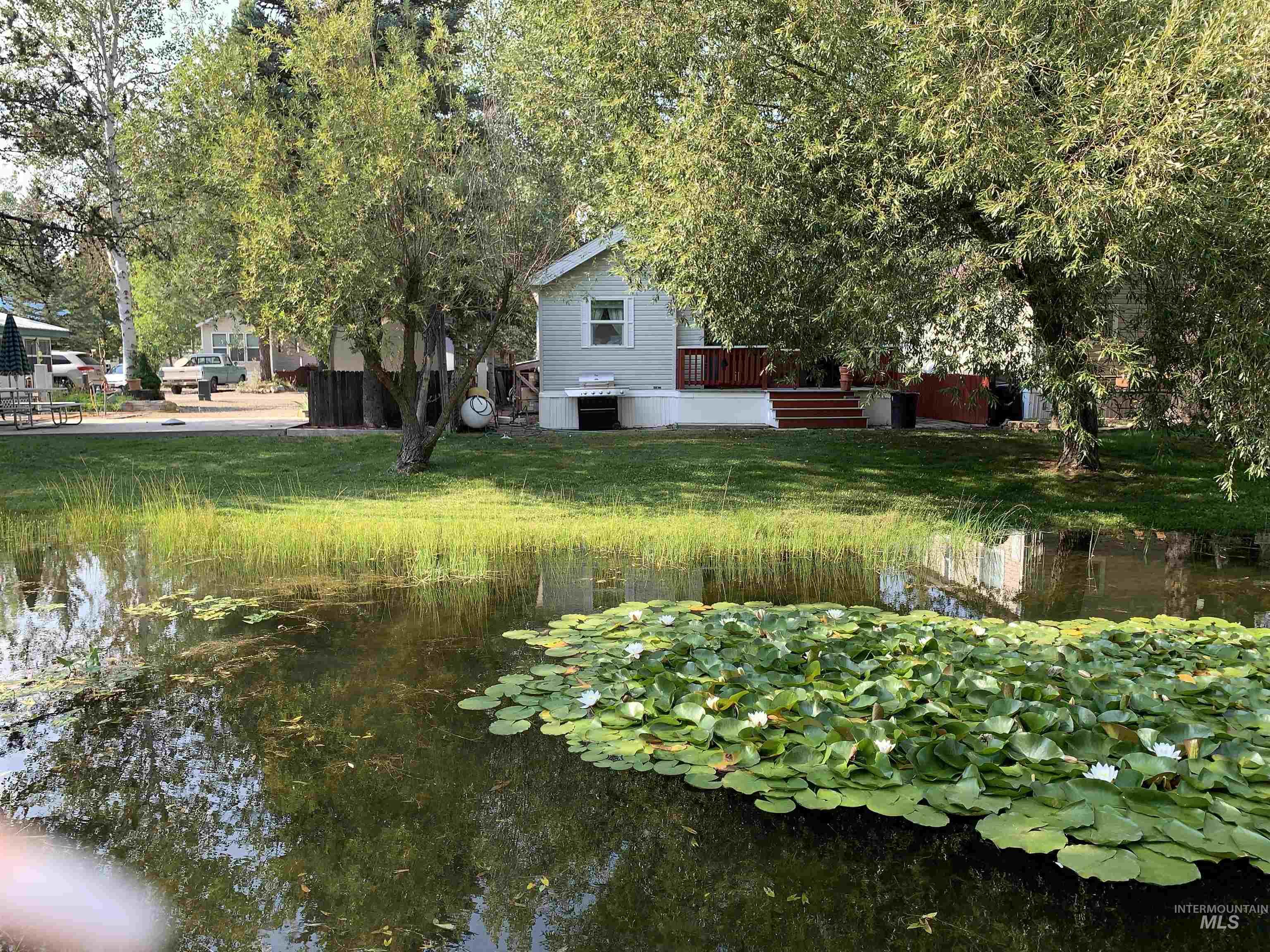 View of yard with a deck with water view