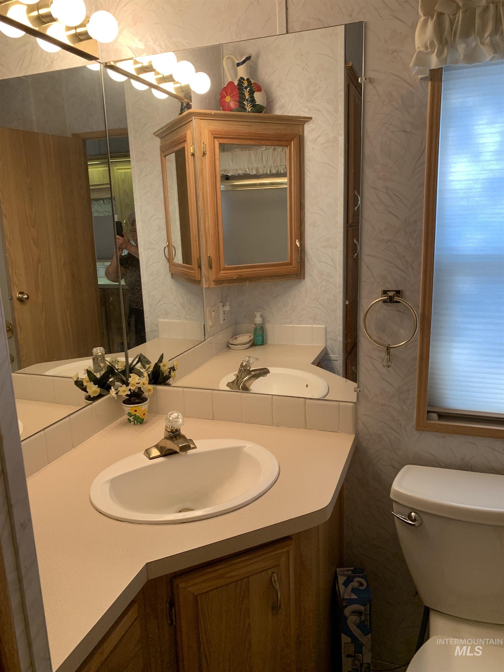 Bathroom featuring vanity and wallpapered walls